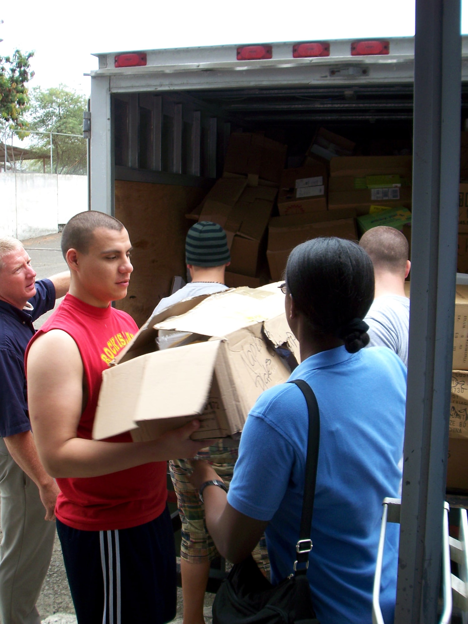 Airman 1st Class Oliver Guerrero (front left) hands a box of donated items to Tech. Sgt. Nicky Ford as Lt. Col. Gary Califf (far left) directs volunteers April 5 near Manta, Ecuador. Air National Guard members from the 186th Air Refueling Wing from Meridian, Miss., who are deployed to Ecuador donated a truckload of donations to the burn center at Rodriguez Zambrano Hospital. Airman Guerrero works force protection for 478th Expeditionary Operations Squadron. Sergeant Ford is a 478th EOS chaplain assistant and Colonel Califf is a 478th EOS chaplain. (U.S. Air Force photo)
