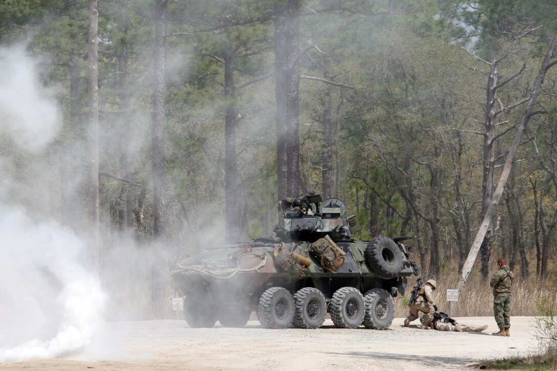 Behind a wall of smoke, a Marine gives aid to a "wounded" buddy during a raid training scenario aboard Camp Lejeune, N.C., April 6th, 2007.  The Marines and sailors of Battalion Landing Team, 3rd Battalion, 8th Marine Regiment, are scheduled to deploy as the Ground Combat Element of the 22nd Marine Expeditionary Unit later this year. (U.S. Marine Corps photo by Cpl. Peter R. Miller)