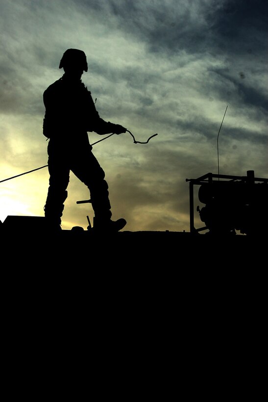 COMBAT OUTPOST RAWAH, IRAQ –Cpl. Nathan B. Damigo, a light armored vehicle driver with Jump platoon, 1st Light Armored Vehicle Battalion, Regimental Combat Team 2 prepares to tie down the tarp roof of the battalion’s mobile combat operations center. The forward COC provides a link in the chain of communication with the battalion’s firm base and its mobile units. Official Marine Corps Photo By Lance Cpl. Ryan C. Heiser.