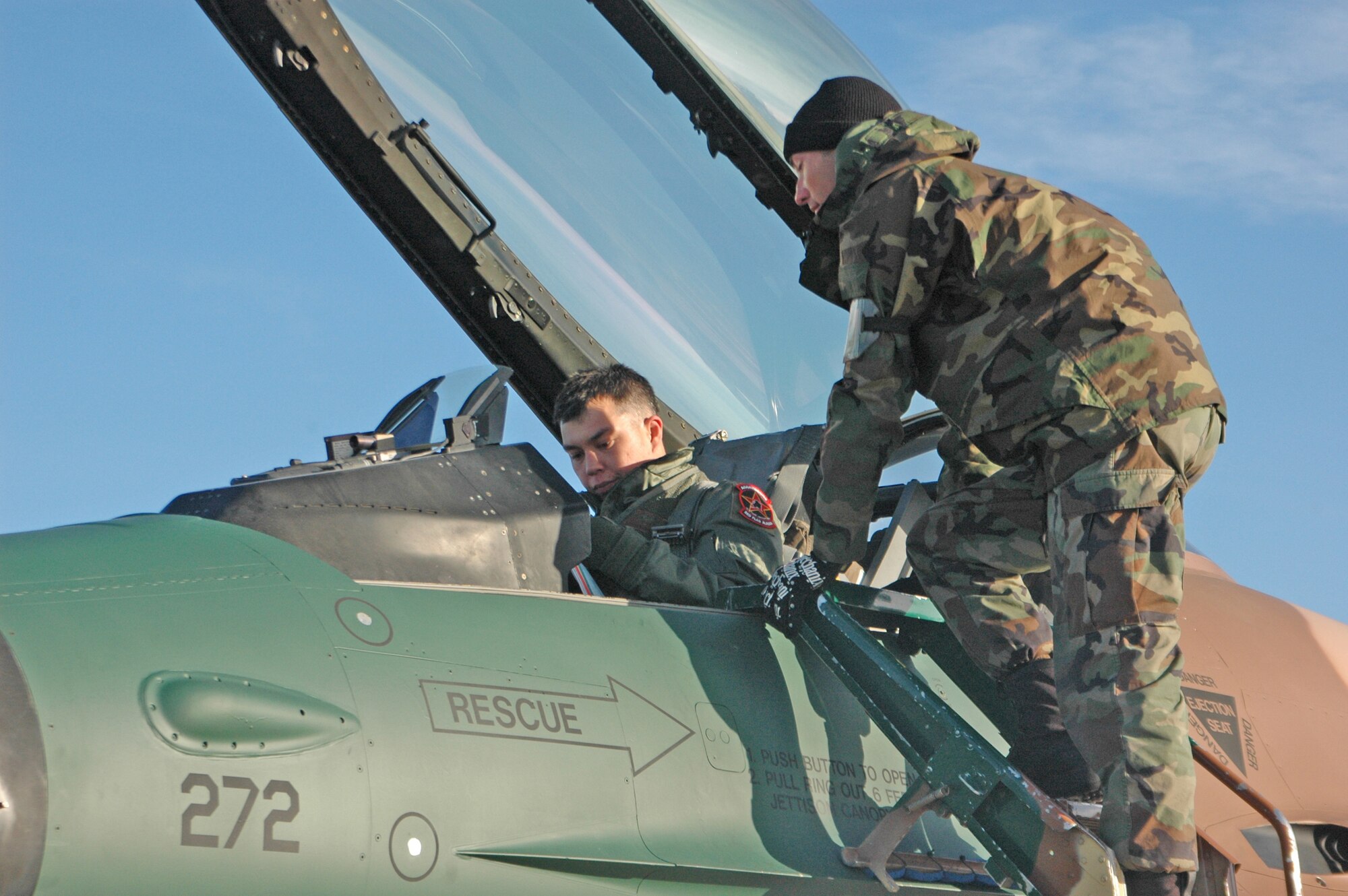 EIELSON AIR FORCE BASE, Alaska--Senior Airman Brian Brammer, 57th Aircraft Maintenance Squadron crew chief, and Capt. Eddie Francis, 64th Aggressor Squadron F-16 Fighter pilot, complete last minute flight checks before a Red Flag-Alaska 07-1 orientation flight April 6. Red Flag-Alaska enables aviation units to sharpen their combat skills by flying ten simulated combat sorties in a realistic threat environment. Additionally, the training allows them to exchange tactics, techniques, and procedures and improve interoperability.  (U.S. Air Force photo by Senior Airman Justin Weaver).