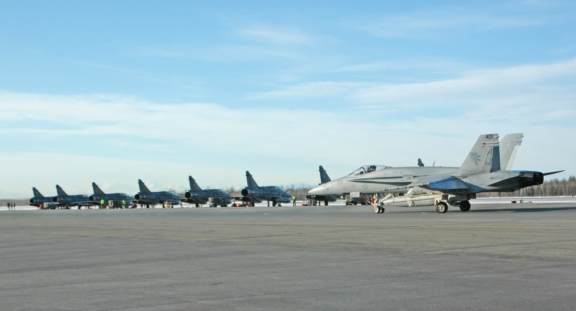 EIELSON AIR FORCE BASE, Alaska--An F-18 Hornet from the Strike Fighter Squadron in Naval Air Station, Va., taxis past French air force Mirage 2000 jets April 6 on the flight line here. More than 1,300 military members from the United States, France and Australia are gathering in the Last Frontier to participate in Red Flag-Alaska 07-1 scheduled from April 5 to 21. (U.S. Air Force photo by Senior Airman Justin Weaver).