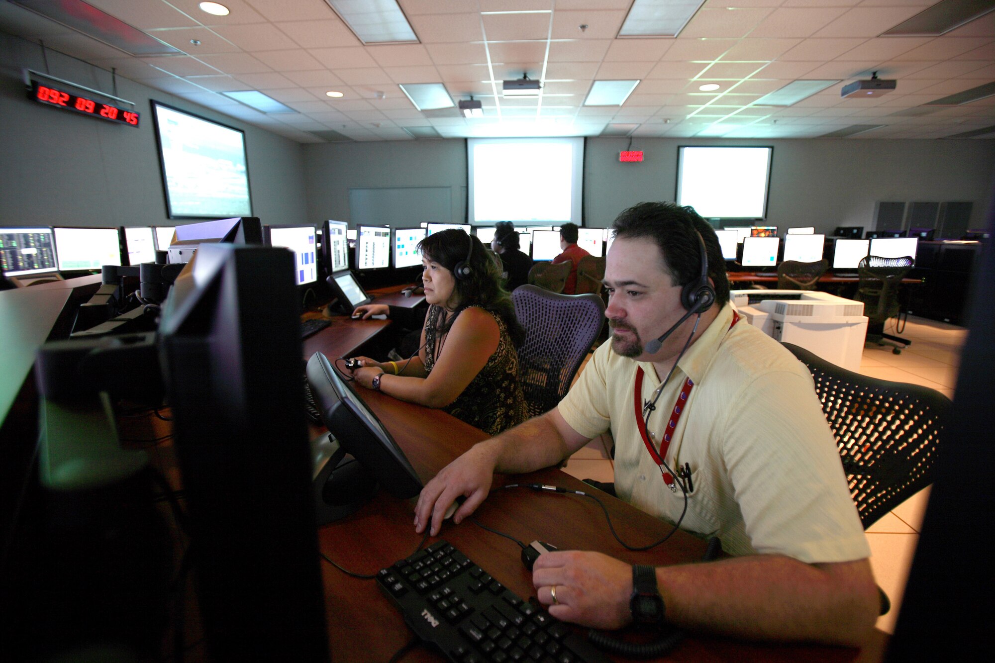 Thomas Caputo, 412th Test Wing security administrator, and Cathy De Lima, 412th Range Squadron range control officer perform computer diagnostics at the F-35 Integrated Test Force control room here April 2. (Photo by Jet Fabara)