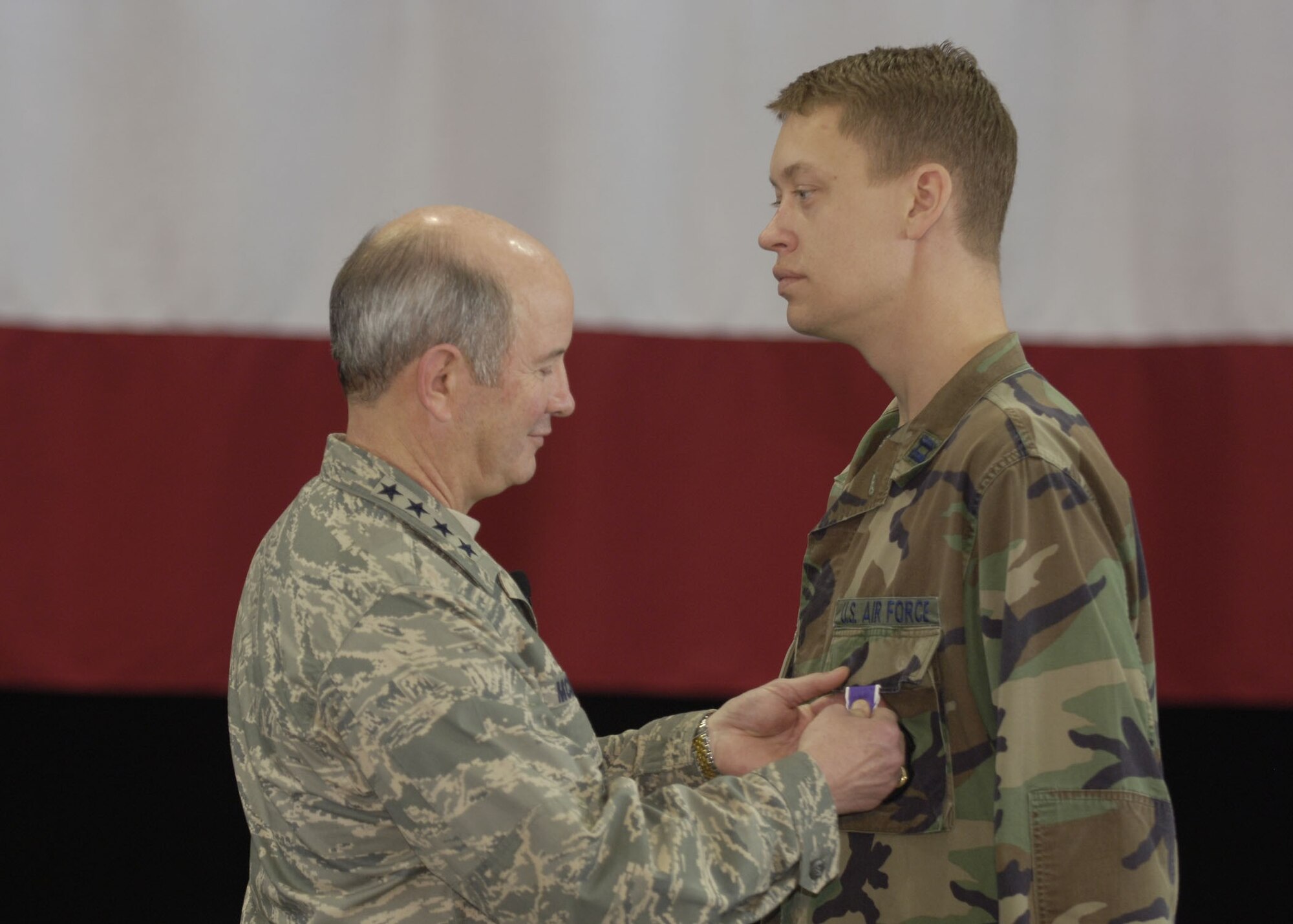 Gen. Duncan McNabb, Air Mobility Command commander, presents a Purple Heart to AMC intelligence officer Capt. Jason Walker, at a recent commander's call at Scott Air Force Base, Ill. (US Air Force photo by Staff Sgt. Tony Tolley)