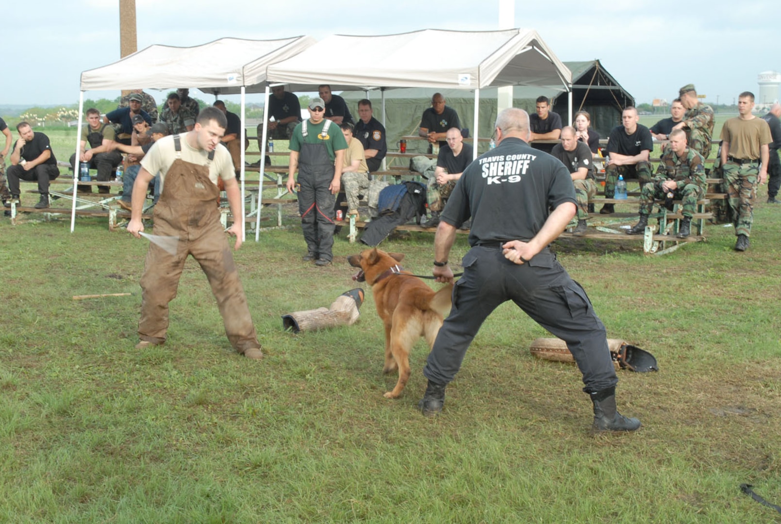 Army Sgt. Doug Timberlake (left), 341st Training Squadron military working dog handler, simulates an aggressor during a bite-building session at a seminar hosted by the 12th Security Forces Squadron Military Working Dog section. Deputy David Deason (right), Travis County Sherrif's Office, holds the leash of K-9 Nero. (US Air Force photo by Rich McFadden)