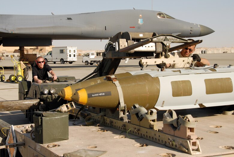 Senior Airman Christopher Silas (left) and Airman 1st Class Kenneth Nealis prepare to load a 2,000 pound joint direct attack munition into a B-1B Lancer in Southwest Asia.  The Airmen are weapons loaders with the 379th Expeditionary Aircraft Maintenance Squadron.  (U.S. Air Force photo/Airman 1st Class Gustavo Gonzalez)
