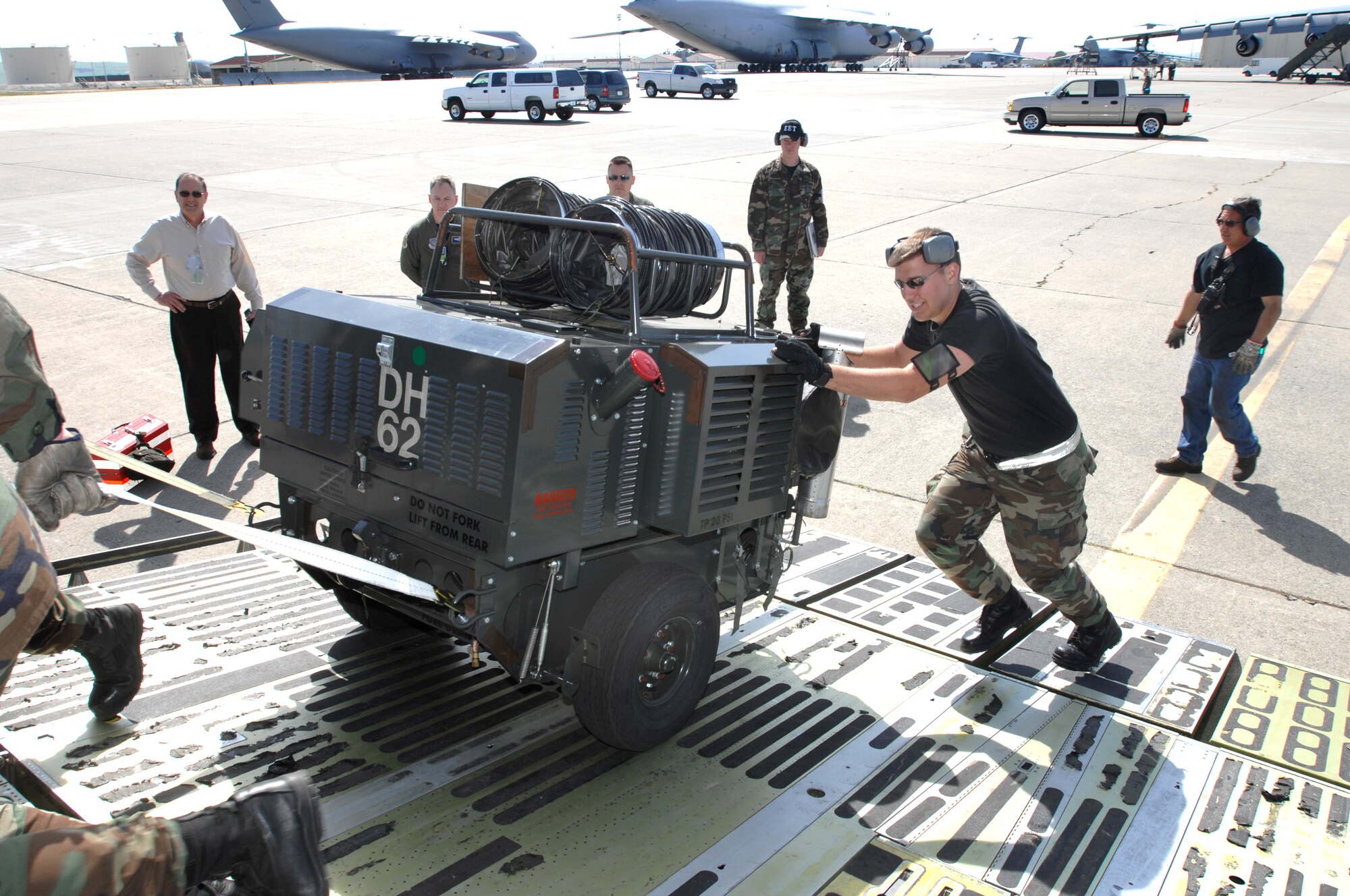 Staff Sgt. Levi Bezdecheck, 60th Aerial Port Squadron Aerial Port Expeditors Load Team member, helps push a generator up a C-5 aircraft ramp during the Crisis Look 07-02 deployment exercise held on Travis Air Force Base, Calif. (U. S. Air Force photo by Nan Wylie)