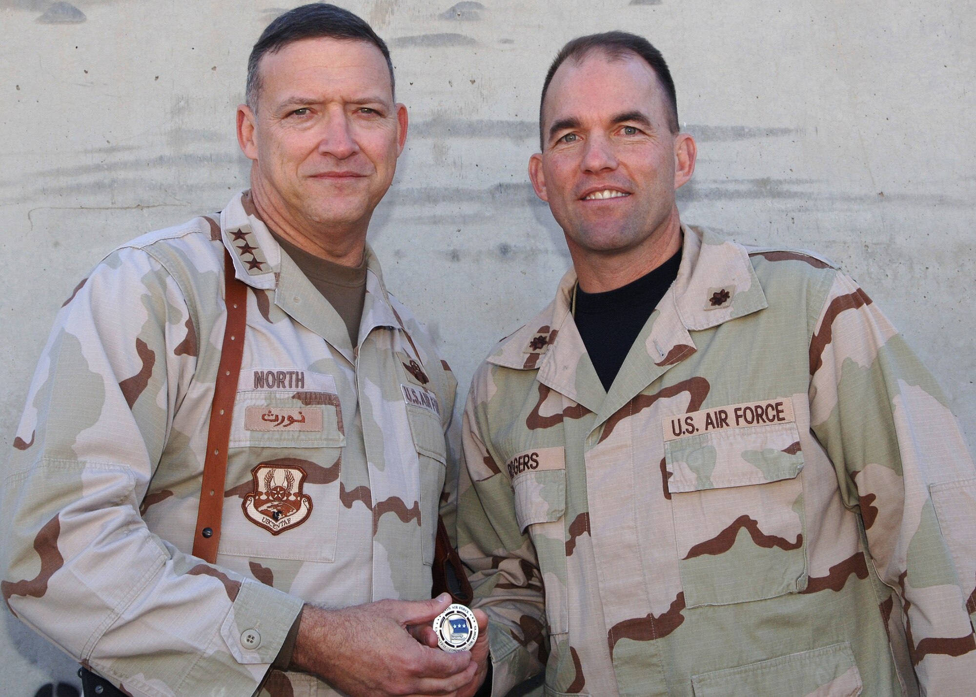 Lt. Gen. Gary North, Commander, U.S. Central Command Air Forces, awards Maj. Mark Rogers, 506th Expeditionary Communications Squadron Information Systems Flight commander, a special recognition coin Dec. 25, 2006. The general recognized the deployed Air Force Recruiting Service communications configuration management chief for his exceptional leadership of a 30-Airman shop lauded for providing outstanding telephone and computer network communications for about 4,000 Soldiers and another 1,400 Airmen and Department of Defense employees at Kirkuk Regional Air Base, Iraq, from September 2006 to January 2007. The major attributes his flight's success to their diligent practice of maintaining open lines of positive communication between Airmen and Soldiers throughout their deployment.