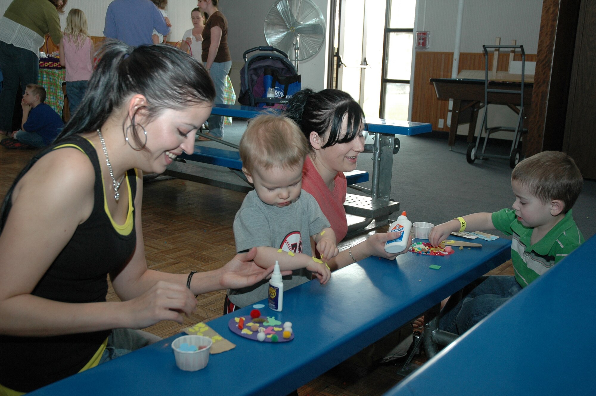 Carmen and Shaelyn help Little Warriors Ethan, 16 months, and Atley, 3, make Easter creations at the arts and crafts booth.