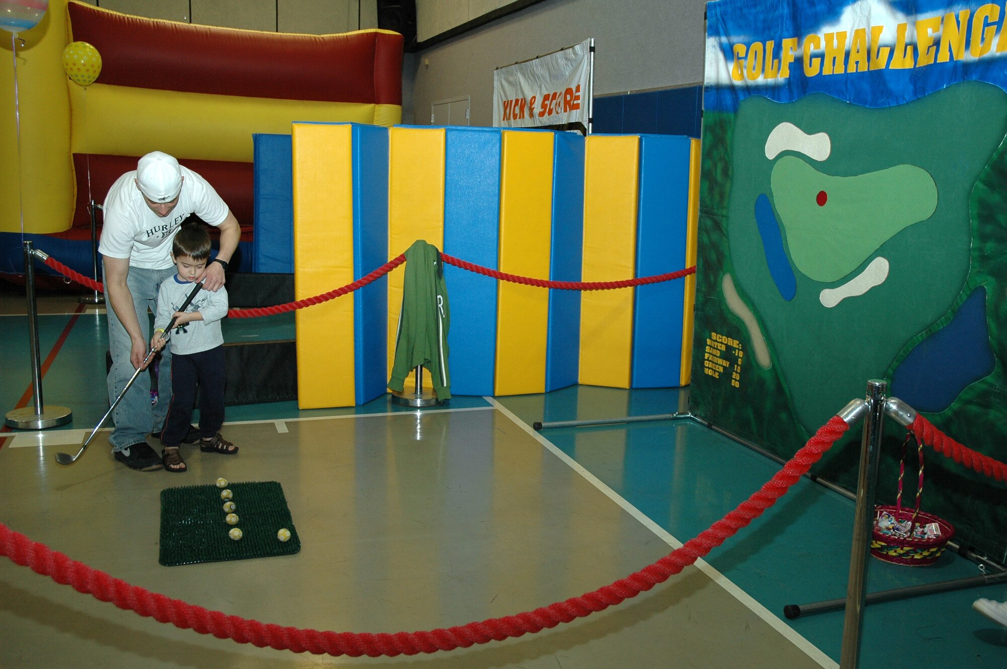 Jared Bratsberg, 341st Logistics Readiness Squadron, helps Little Warrior Damien, 4, chip for a prize.