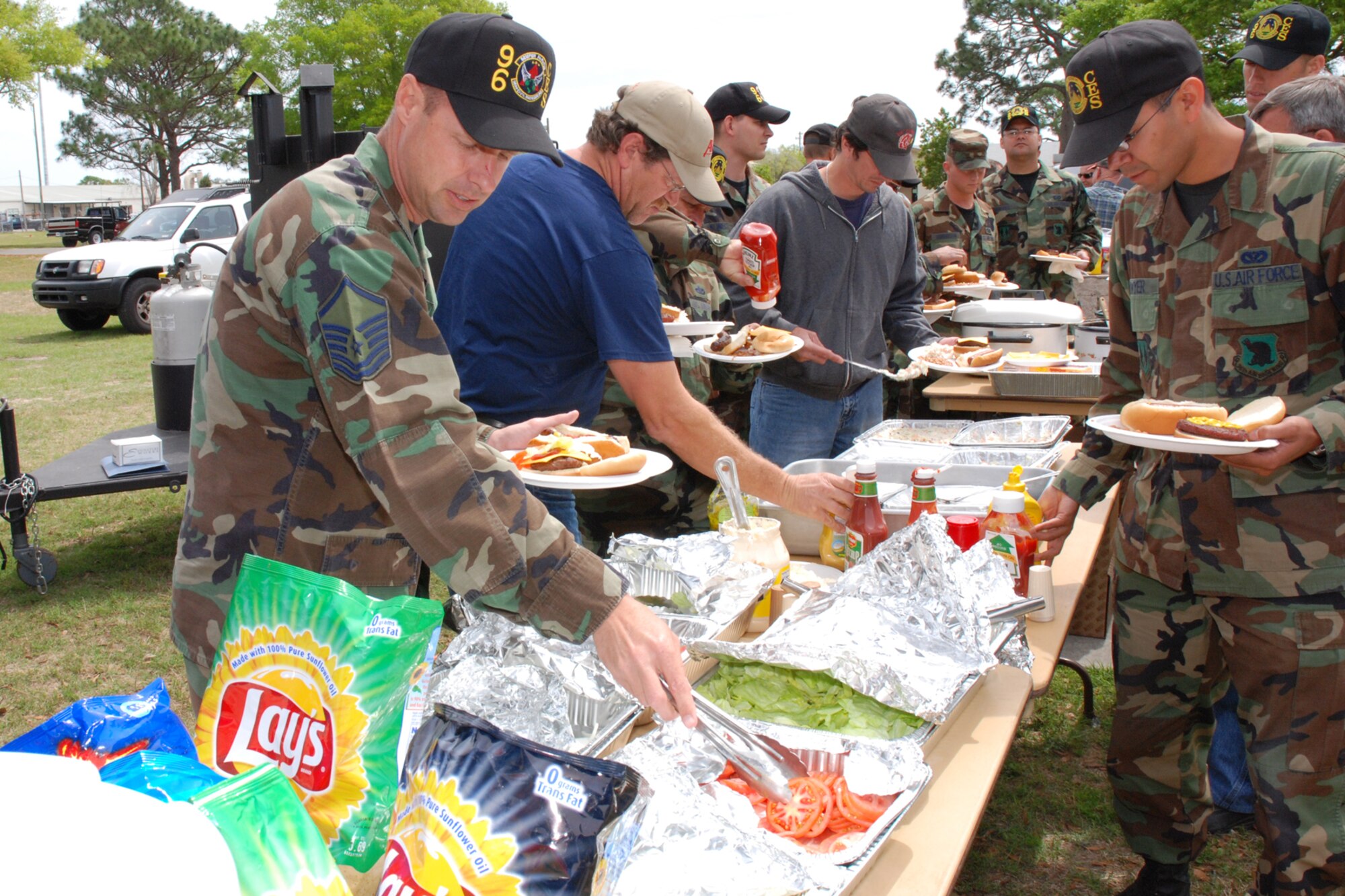 EGLIN AIR FORCE BASE, Fla. -- Master Sgt. Pat Miller, 96th Civil Engineer Squadron fire department chief of readiness, fixes up his hamburger with a tomato at a barbecue to treat their deploying members and the families to a cookout on the eve of their deployments. To give them a proper send off and to meet their families, volunteers and co-workers cooked hamburgers, hotdogs and sausages on the grills. More than 35 members from the squadron will be deploying as a team in the next two weeks and many others will deploy within the next two months. (U.S. Air Force Photo by Staff Sgt. Mike Meares)