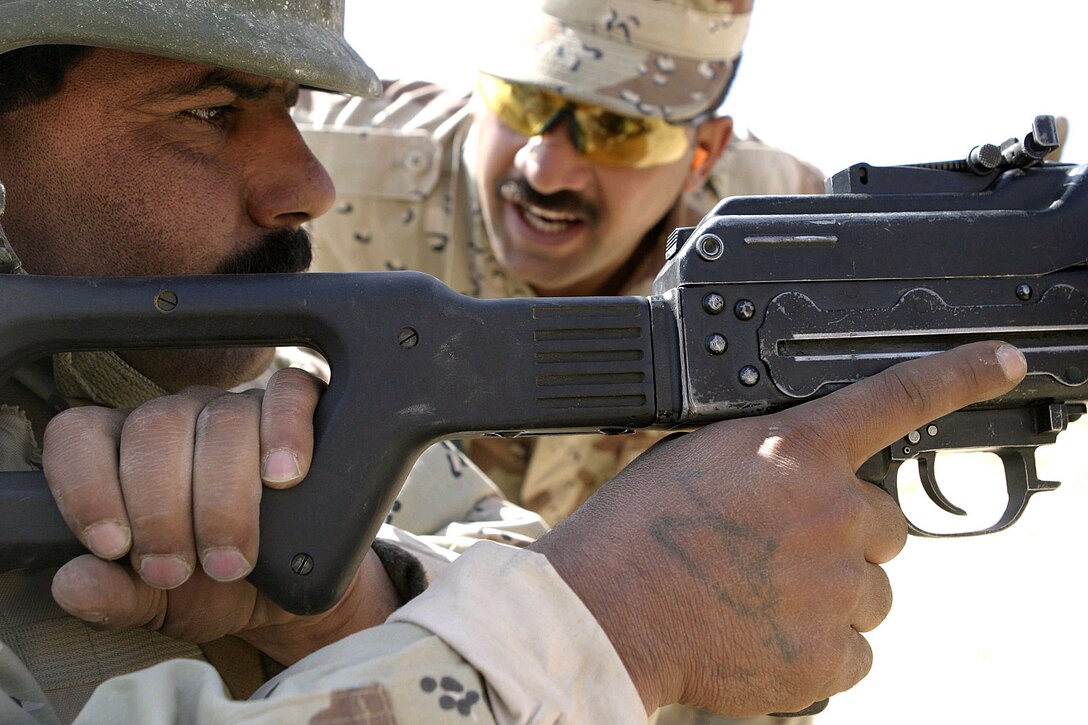 Sgt. Emad Maard, an instructor at the Iraqi Army School of Infantry, carefully monitors one of the Iraqi Army soldiers during a recent PKC machine gun range, April 4, 2007. 