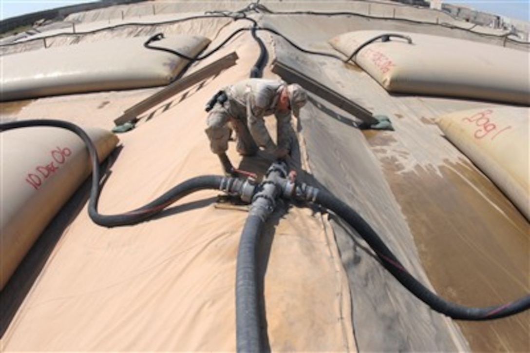 U.S. Air Force Tech. Sgt. Adam Giles closes a block valve to a 50,000 gallon JP-8 fuel bladder in a bladder farm at Kirkuk Regional Air Base, Iraq, on April 5, 2007.  The bladder farm can provide enough fuel for five surrounding forward operating bases as well as Army and Air Force operations at Kirkuk.  Giles is a fuels specialist with the 506th Expeditionary Logistics Readiness Squadron.  