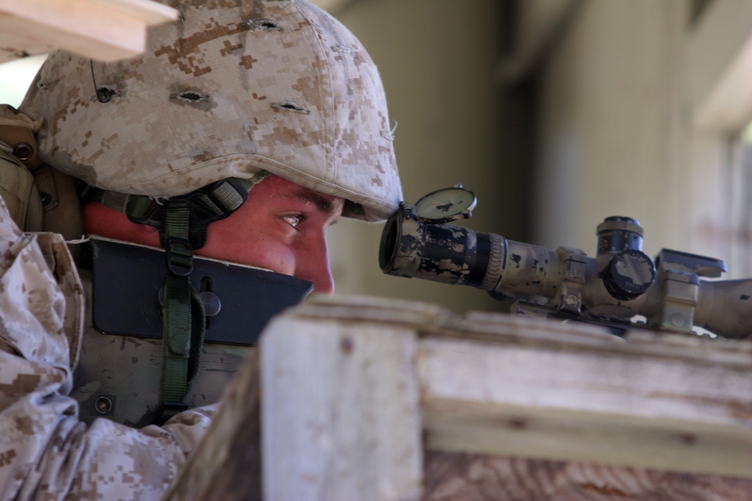 A student peers through the scope of his M40-A3 sniper rifle during the team-urban assault portion of the Marine Corps Special Operations Training Group Urban Sniper Course held aboard Camp Lejeune, N.C., April 5, 2007.  Two-man teams assaulted through the "Dodge City" multipurpose shooting range as a part of the course and were graded on their abilities to accurately engage multiple targets with precision weapons.  (U.S. Marine Corps photo by Cpl. Peter R. Miller)