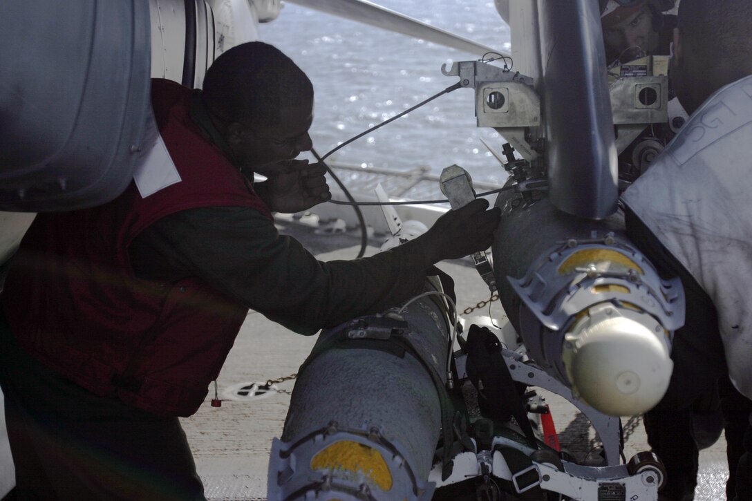 Sgt. Roland M. Simmons, an aviation ordnance Marine in the 26th Marine Expeditionary Unit's Marine Medium Helicopter Squadron-264 (Reinforced) loads a Guided Bomb Unit-38 Joint Direct Attack Munition (JDAM) onto the wing of an AV-8B Harrier II, April 7, 2007, aboard USS Bataan.  The 26th MEU and the Bataan Strike Group are currently conducting Maritime Security Operations in the Central Arabian Gulf.  (Official Marine Corps photo by Cpl. Aaron J. Rock)