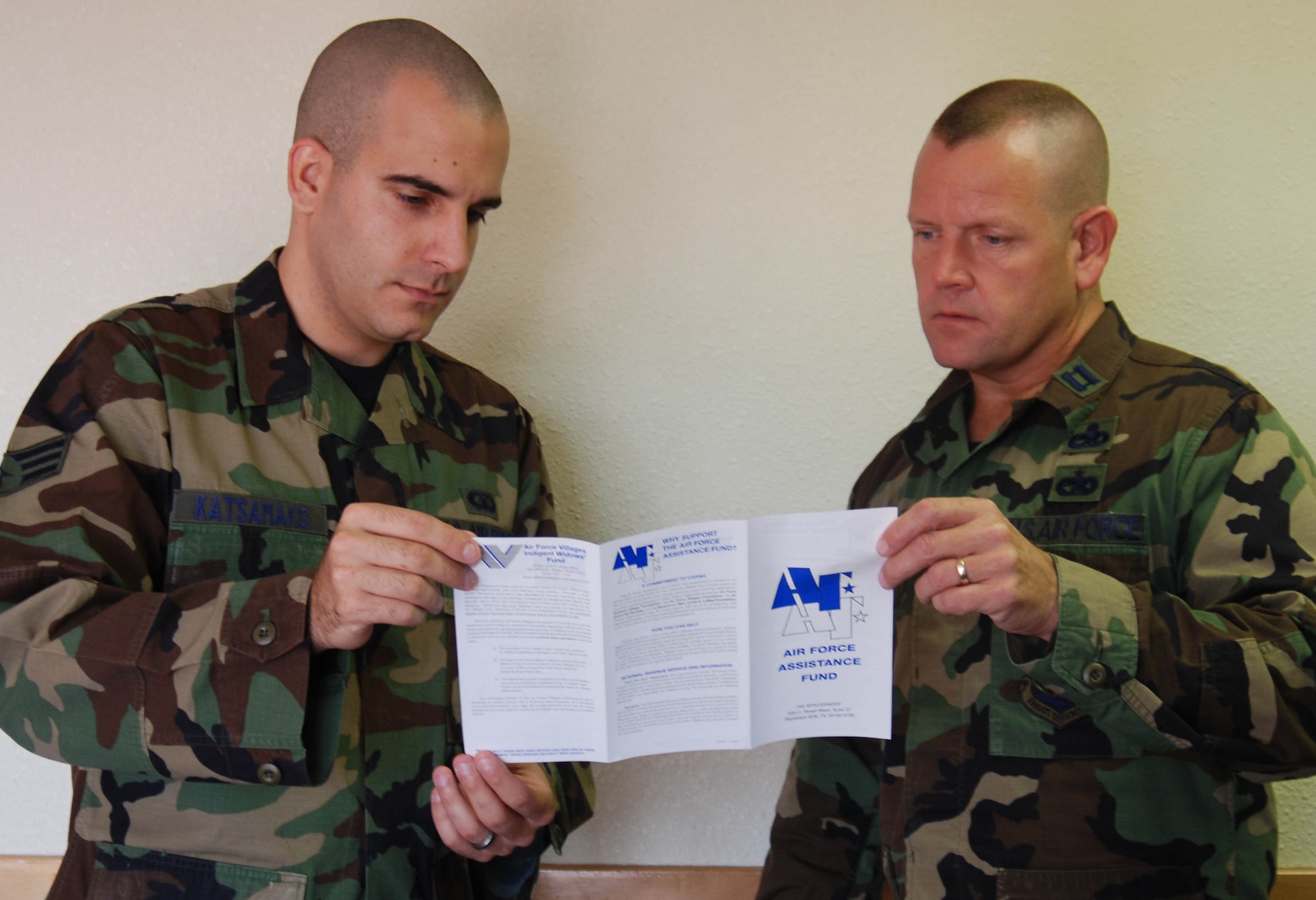 Senior Airman George Katsamakis, from the 36th Operations Support Squadron, and Capt. John Creighton, from the 506th Expeditionary Air Refueling Squadron, review the Air Force Assistance Fund pamphlet.   Both are AFAF unit project officers.  The AFAF campaign ends April 15. ( Photo by Airman Basic Evan Carter/36th Wing Public Affairs)