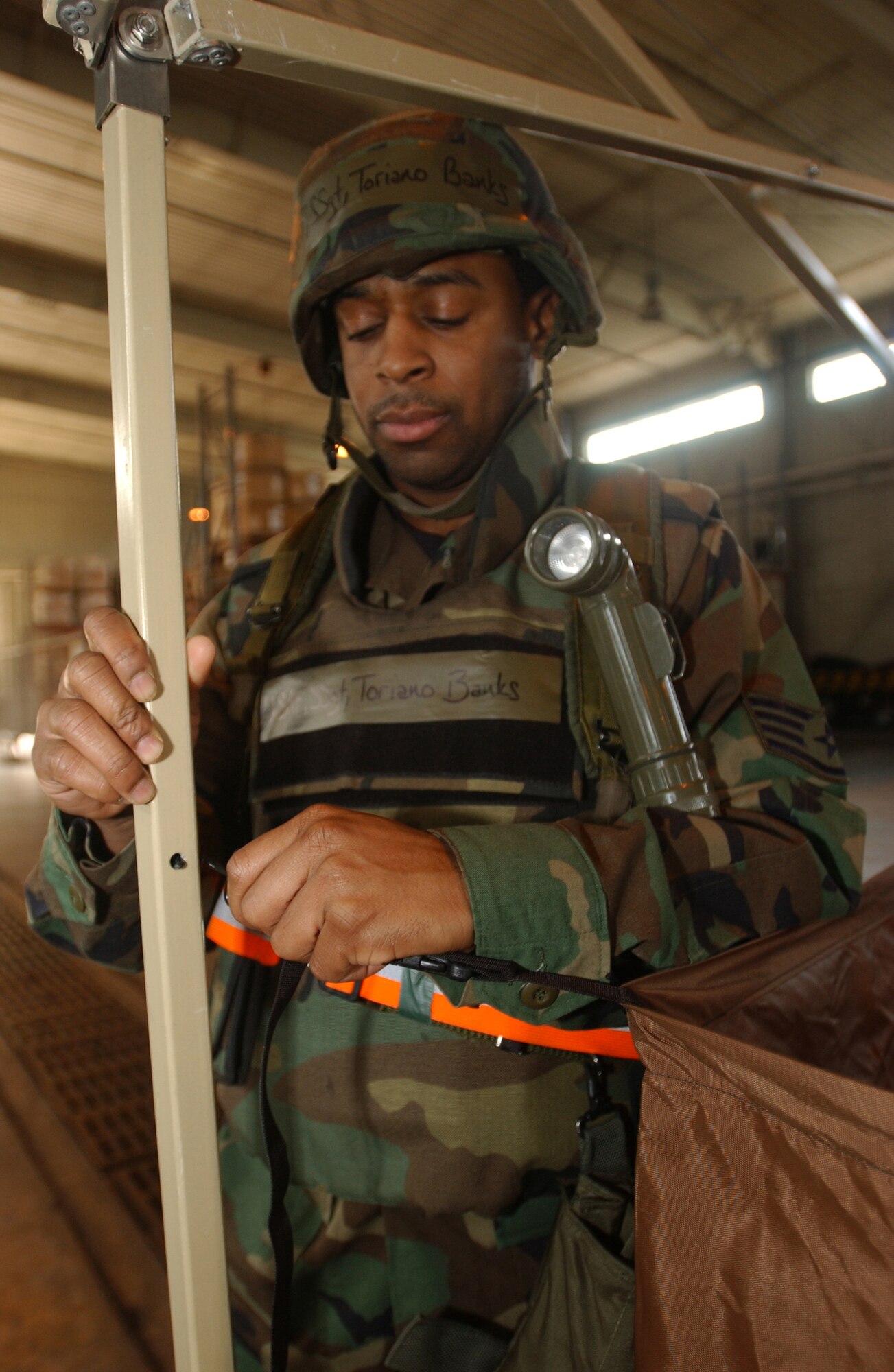 KUNSAN AIR BASE, Republic of Korea  March 22, 2007 -- Staff Sgt. Toriano Banks attaches a hook for the gas mask cleaning portion of a chemical contamination area March 22. The CCA was built to decontaminate Airmen following contamination from a mock chemical attack. Sgt. Banks is a member of the 8th Comptroller Squadron, the unit responsible for building and manning a CCA day or night. (Air Force photo/Senior Airman Darnell Cannady)