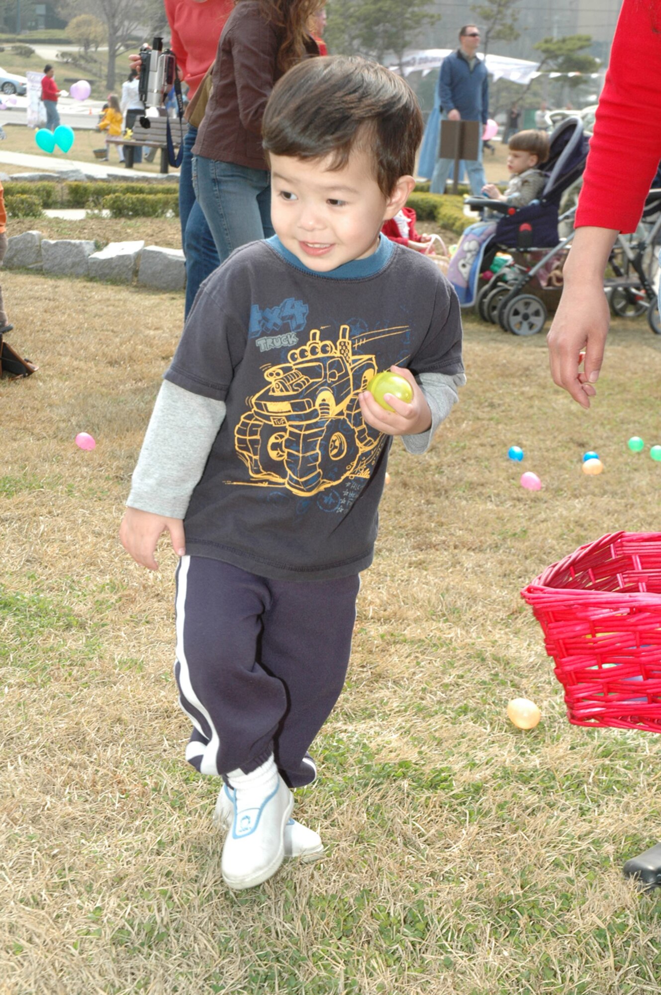 OSAN AIR BASE, Republic of Korea --  Matthew Westman, the 2-year-old son of Ann Westman, picks up plastic eggs at the Easter Egg Hunt at Turumi Park on Saturday. The 51st Services Squadron hosted the event, during which children traded the eggs for candy. (U.S. Air Force photo by Staff Sgt. Benjamin Rojek)