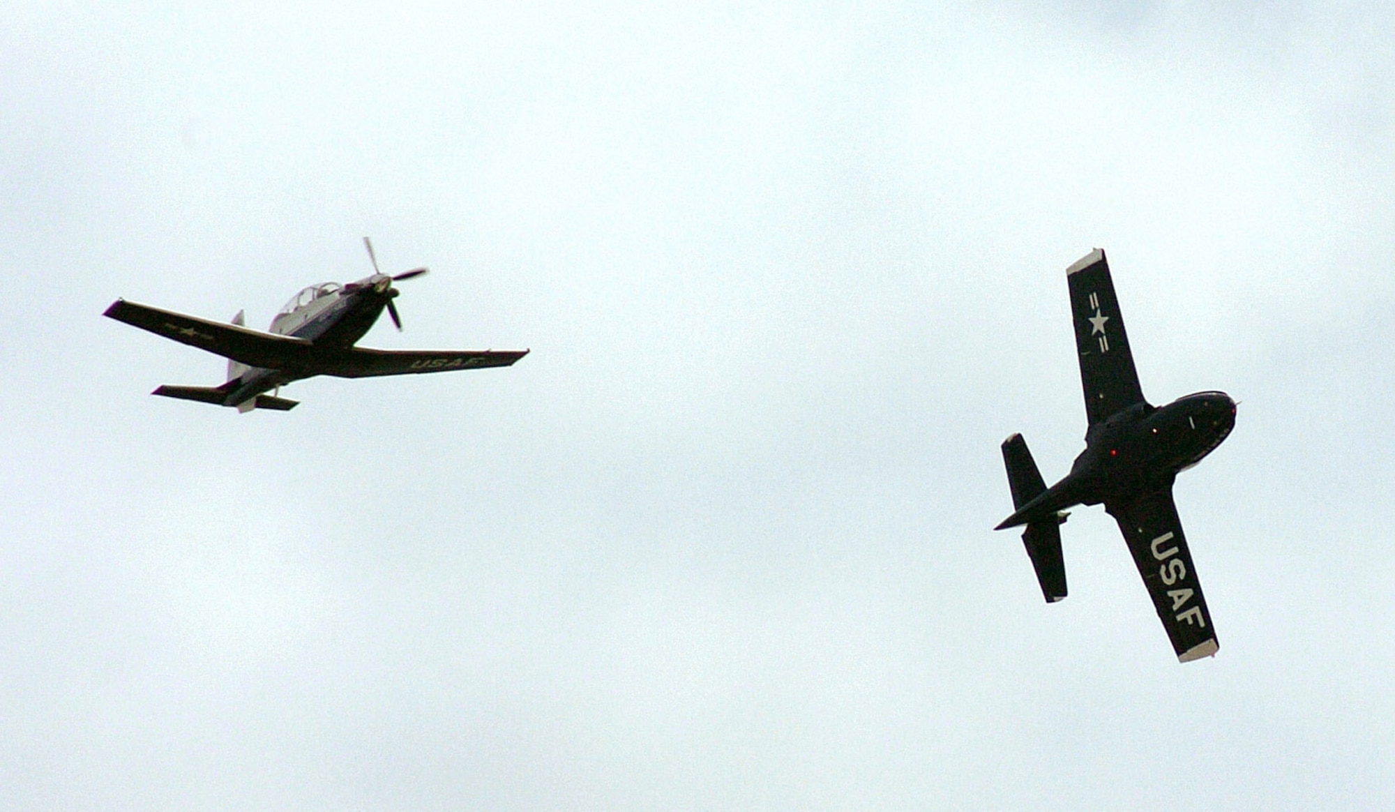 The last Randolph T-37B Tweet peels off to the west while a T-6Texan II flies ahead symbolizing the past and future of the primary pilot instructor training mission. (U.S. Air Force photo/Dave Terry) 