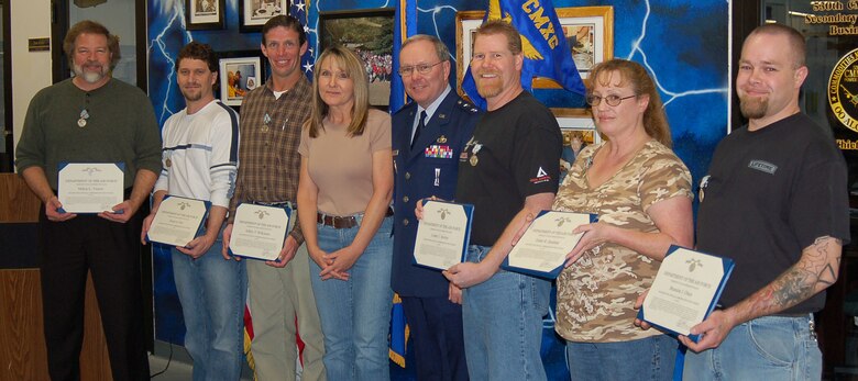 Kathleen Moss, center, whose life was saved by the 530 CMMXS team, assisted Maj. Gen. Kevin Sullivan in presenting their Valor awards. Pictures from left are Milton Vierow, Dustin Flint, Jeffery Wilkinson, Ms. Moss, General Sullivan, Lonny Sexton, Esther Hardman and Brandon Olsen.
