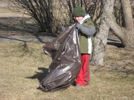 MINOT AIR FORCE BASE, N.D. -- Evan Bell, a Boy Scout and son of Maureen and Col. Paul Bell, 5th Bomb Wing vice commander, helps clean Bud Ebert Park here April 7. Scout members, including Cub and Boy Scouts, performed the clean-up as part of a community service project aimed at instilling personal growth and helping complete the scouts’ requirements for an activity pin. (courtesy photo)
