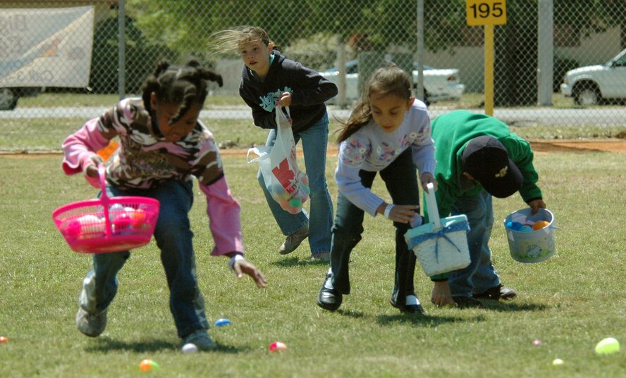 Children hop around the ball field to collect the most eggs  at the Youth Center's Annual Big Bunny Egg Hunt April 7.  Eggs were filled with candy and prize tickets.  Approximately 15,000 plastic eggs were stuffed by volunteers to be hidden and found by children of all ages. (U.S. Air Force photo by Chrissy Cuttita)