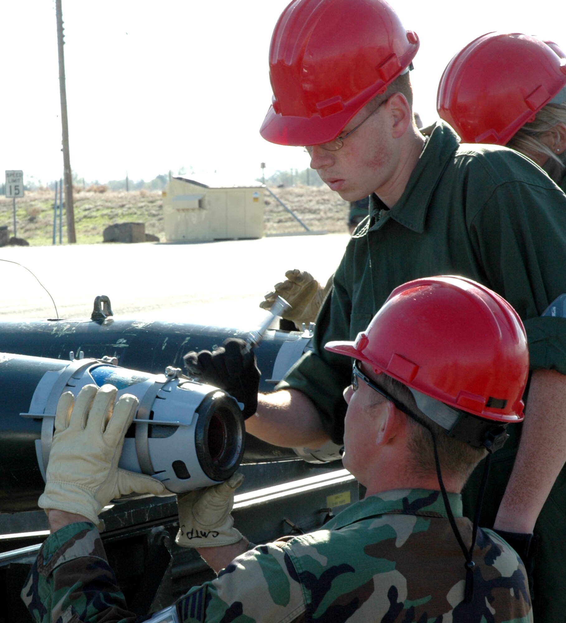 MOUNTAIN HOME AIR FORCE BASE, Idaho -- Staff Sgt. Corey Hendrickson (bottom) and Airman 1st Class Travis Briese install the forward aero-surfaces assembly on a GBU-38 laser-guided bomb during a training program here. This recurring training ensures munitions troops remain proficient when building bombs. Air Force photo by Airman Samantha S. DeVries