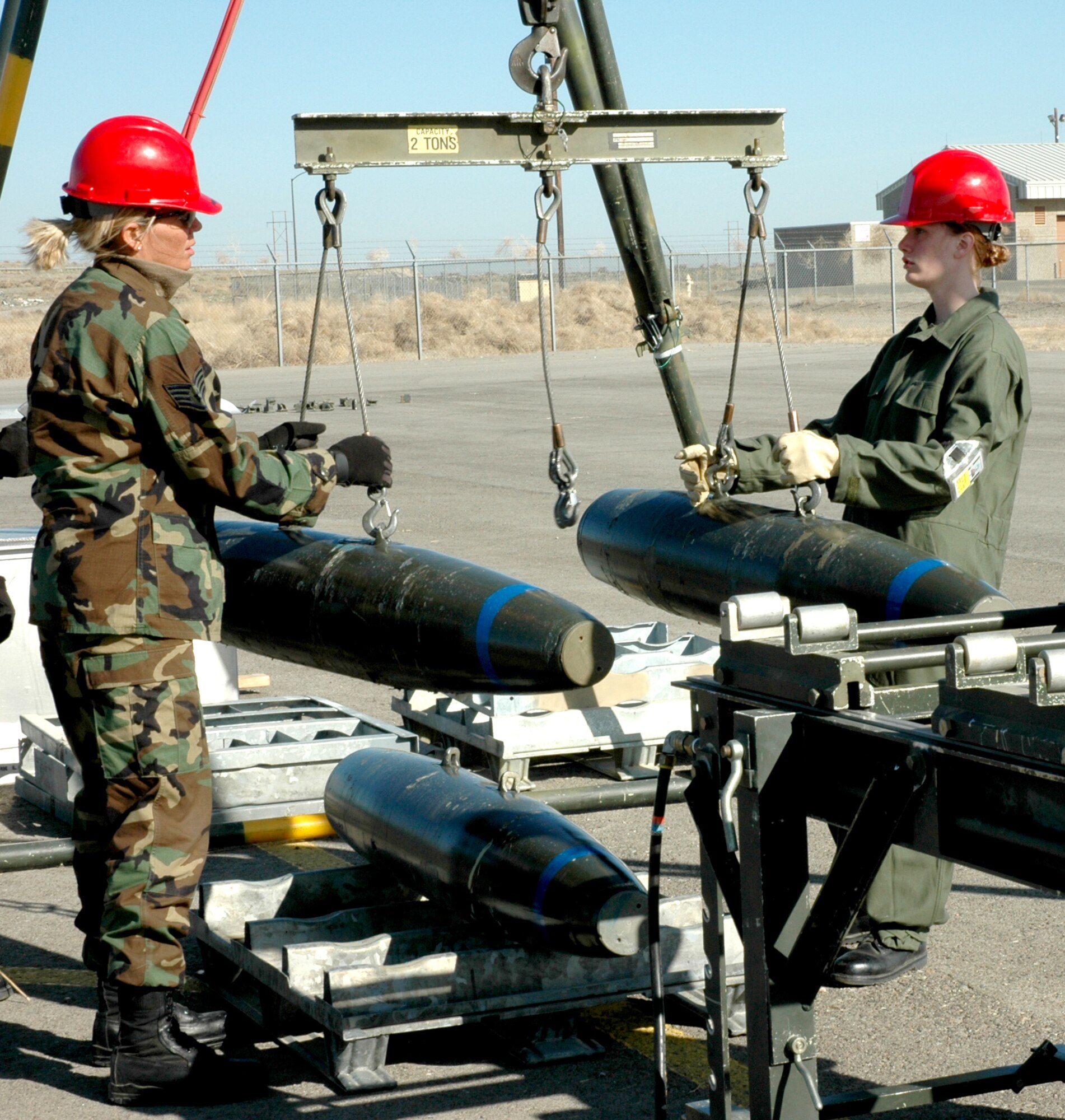 MOUNTAIN HOME AIR FORCE BASE, Idaho -- Staff Sgt. Lisa Kroier, left, and Airman 1st Class Angel Wendell from the 366th Equipment Maintenance Squadron place inert MK-82 bomb bodies on a gantry table during a recent training class here.  Munitions Airmen use these training programs to stay proficient in their bomb-building skills. Air Force photo by Airman Samantha S. DeVries