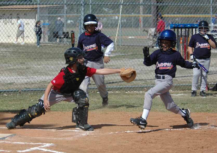 Phillies catcher Ollie Frasier gets ready to tag out Braves player Chase McCarn who is running toward home base during the first game of the season at the Youth Center. Braves won the game, 9-7, and the season will continue until May. (U.S. Air Force photo by Chrissy Cuttita)
