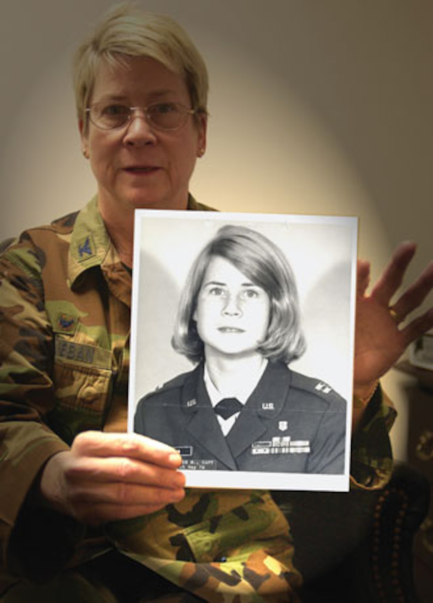 Colonel Janice McKibban holding a photograph of herself as a captain, taken in 1976. (U.S. Air Force photographic by Staff Sgt. Amy Abbott)