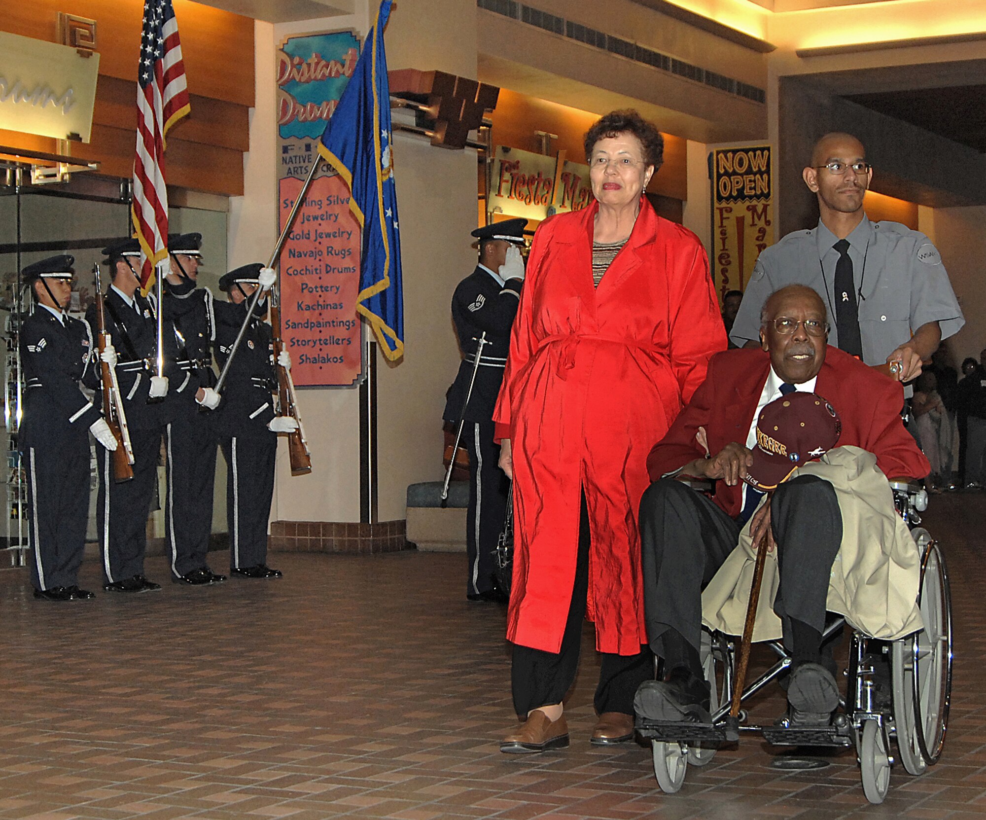 Tuskegee Airman Robert Lawrence is honored by the Kirtland AFB Honor Guard as he and wife Tina pass down a terminal in the Albuquerque International Sunport Saturday. Mr. Lawrence returned from Washington, D.C., where he and the other Tuskegee Airmen received the Congressional Gold Medal of Honor, which is the highest civilian award bestowed by the U.S. Congress. The medal was first presented in 1776 to George Washington since then it has been awarded to American heroes in all walks of life. (U.S. Air Force photo by Adam Wooten)