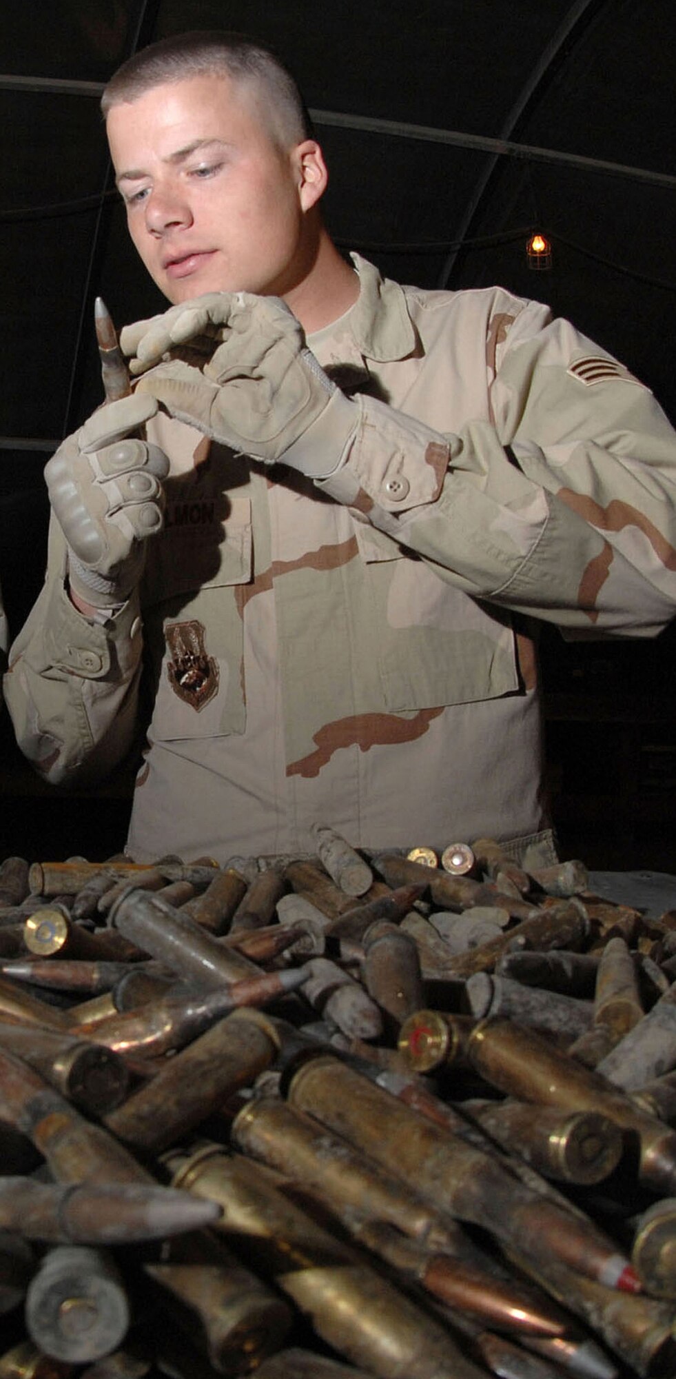 Staff Sgt. Michael Bigelow (left) and Senior Airman David Hallmon inspect unfired ammunition March 21 at Kirkuk Air Base, Iraq. All unserviceable ammo is sent to the explosive ordnance disposal team for detonation. The Airmen are munitions specialists with the 506th Air Expeditionary Group. Airman Hallmon is deployed from the 377th Maintenance Squadron (U.S. Air Force photo/Senior Airman Bradley A. Lail) 