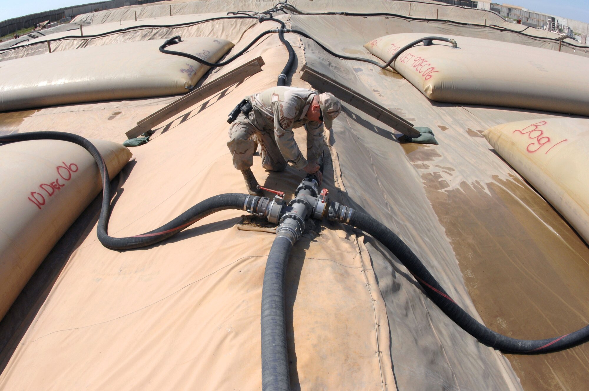Tech. Sgt. Adam Giles closes a block valve to a 50,000-gallon JP-8 fuel bladder April 5 at Kirkuk Air Base in Iraq. Sergeant Giles is a fuels supervisor with the 506th Expeditionary Logistics Readiness Squadron. (U.S. Air Force photo/Senior Airman Bradley A. Lail)
