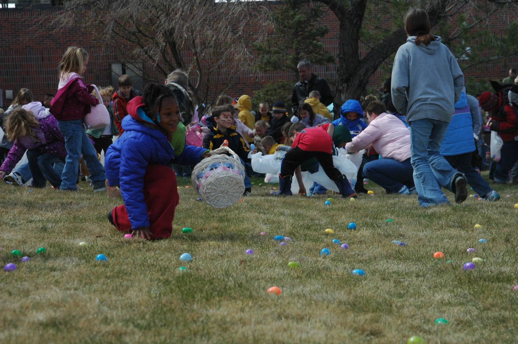 Children scramble grabbing Easter eggs. A free base-wide Easter egg hunt was held April 7 outside the base exchange. Approximately 600 children met the Easter Bunny, hunted for eggs and got free face paintings. The children were divided into two age groups to hunt for the 3,000 eggs which all contained candy or prize coupons.