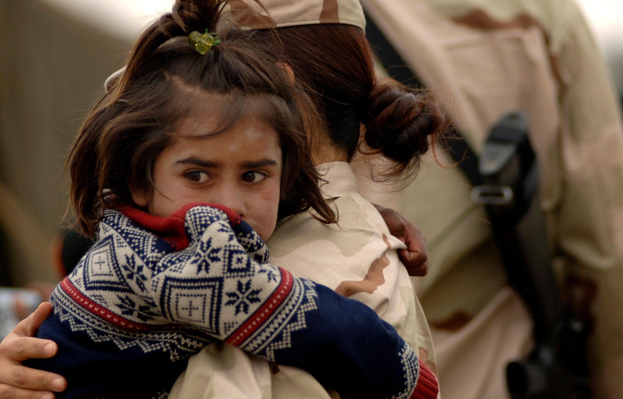An Airman holds a local refugee child April 8 in Dar Ul Aman in support of the Volunteer Community Reach Program in Kabul, Afghanistan. Volunteers for the outreach program provided a diversion for the children so that other volunteers could distribute, without distraction, 200 bags of clothes, shoes and toys donated from U.S. citizens. Each month the volunteers bring donated goods to the refugees. (U.S. Air Force photo/Tech. Sgt. Cecilio M. Ricardo Jr.)