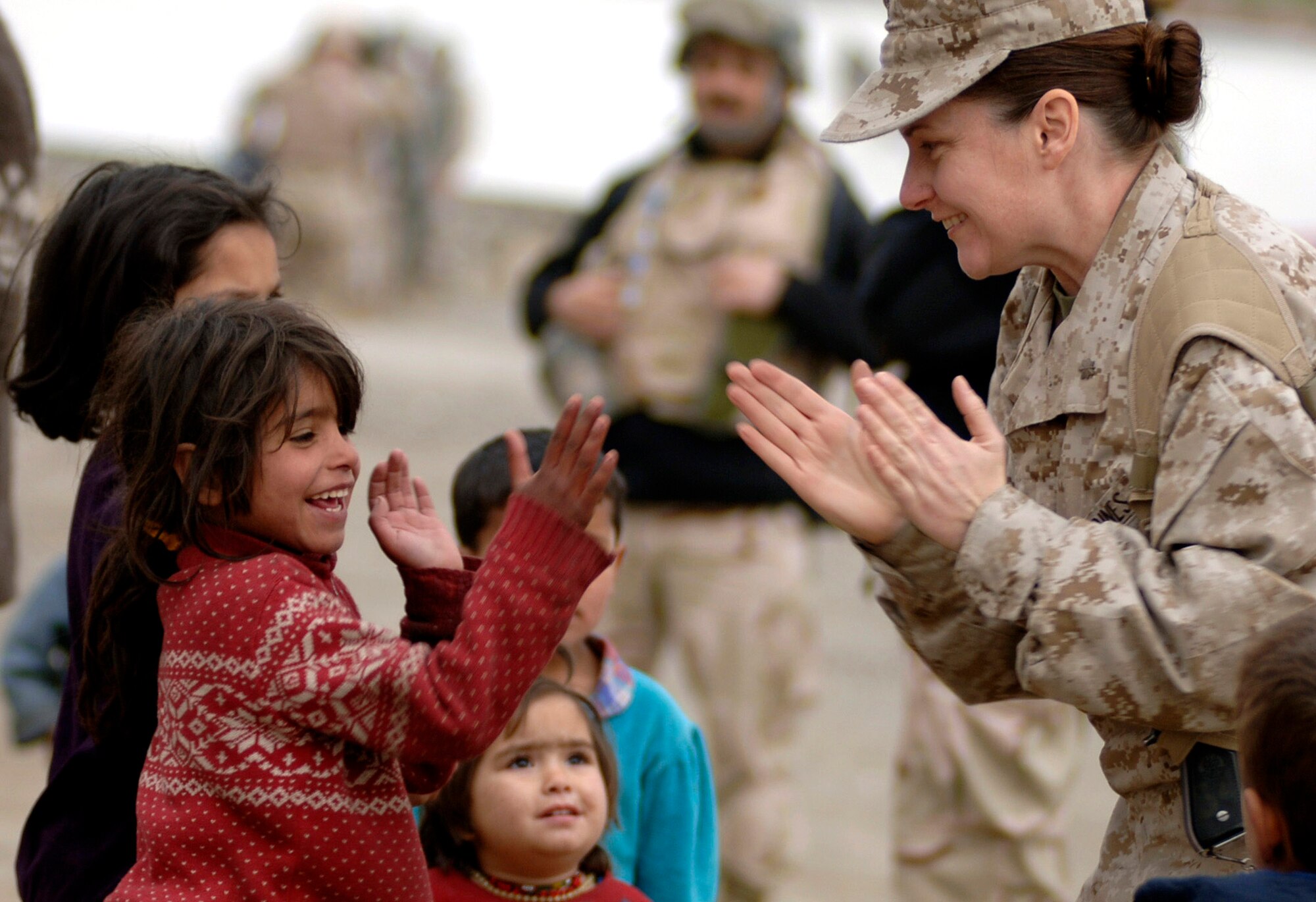 Marine Maj. Shawn Haney plays with a local refugee child April 8 in Dar Ul Aman in support of the Volunteer Community Reach Program in Kabul, Afghanistan. Volunteers for the outreach program provided a diversion for the children so that other volunteers could distribute, without distraction, 200 bags of clothes, shoes and toys donated from U.S. citizens. Each month the volunteers bring donated goods to the refugees. Maj. Haney is a religious cultural affairs mentor at the Human Resource Division within the Combined Security Training Command. (U.S. Air Force photo/Tech. Sgt. Cecilio M. Ricardo Jr.)
