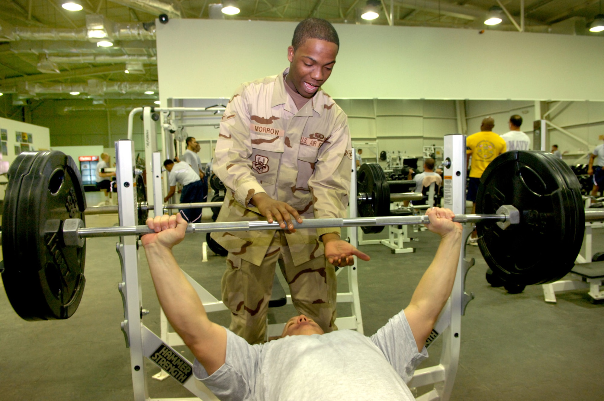 Airman Aaron Morrow spots a fellow Airman on the bench press at the base fitness center. Airman Morrow is a certified fitness trainer deployed from the 366th Services Squadron at Mountain Home AFB, Idaho to the 332nd Expeditionary Services Squadron, Balad AB, Iraq. (U. S. Air Force photo/Staff Sgt. Michael R. Holzworth)