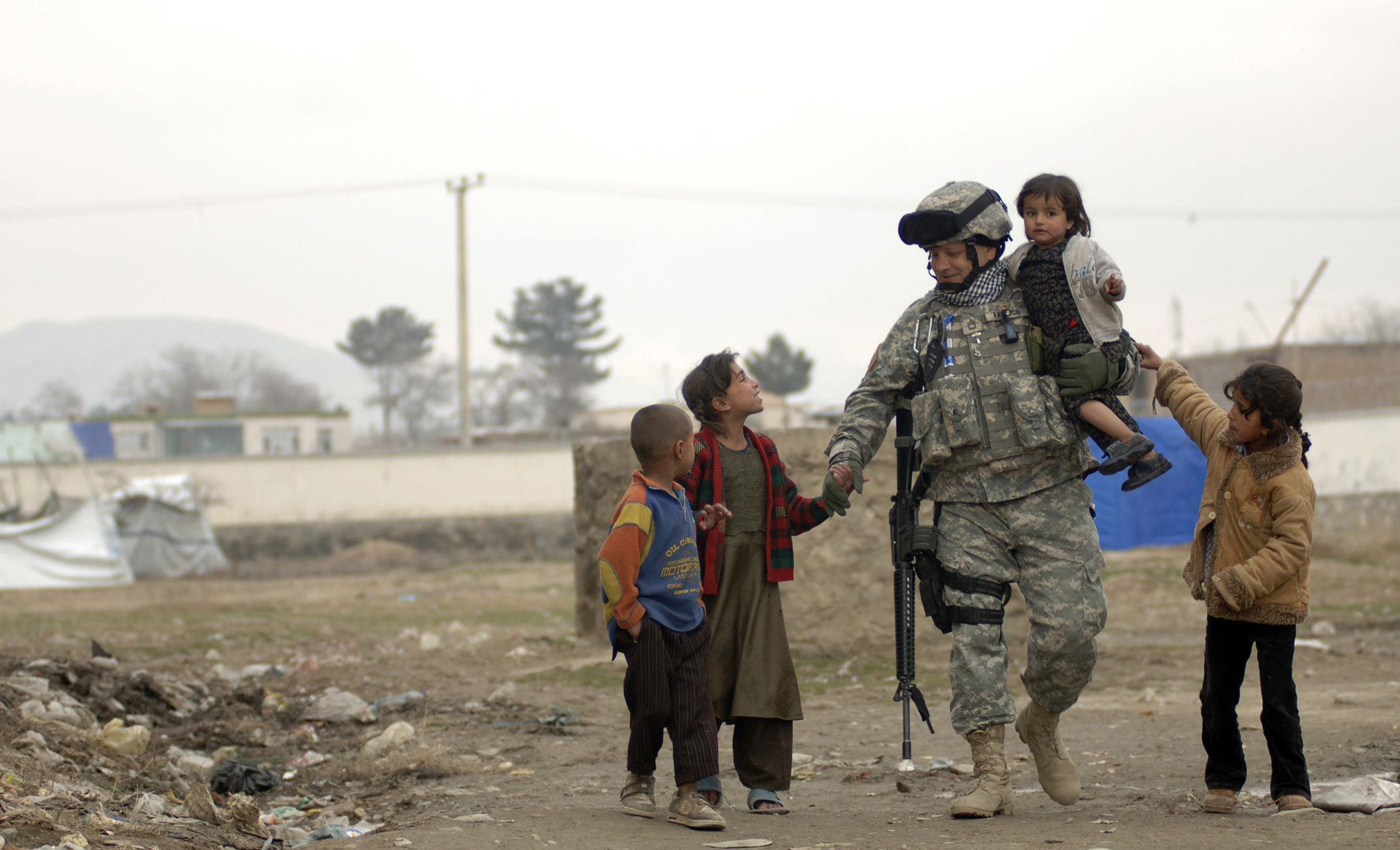 U.S. Army Sgt. 1st Class Ed Franco plays with local refugee children in