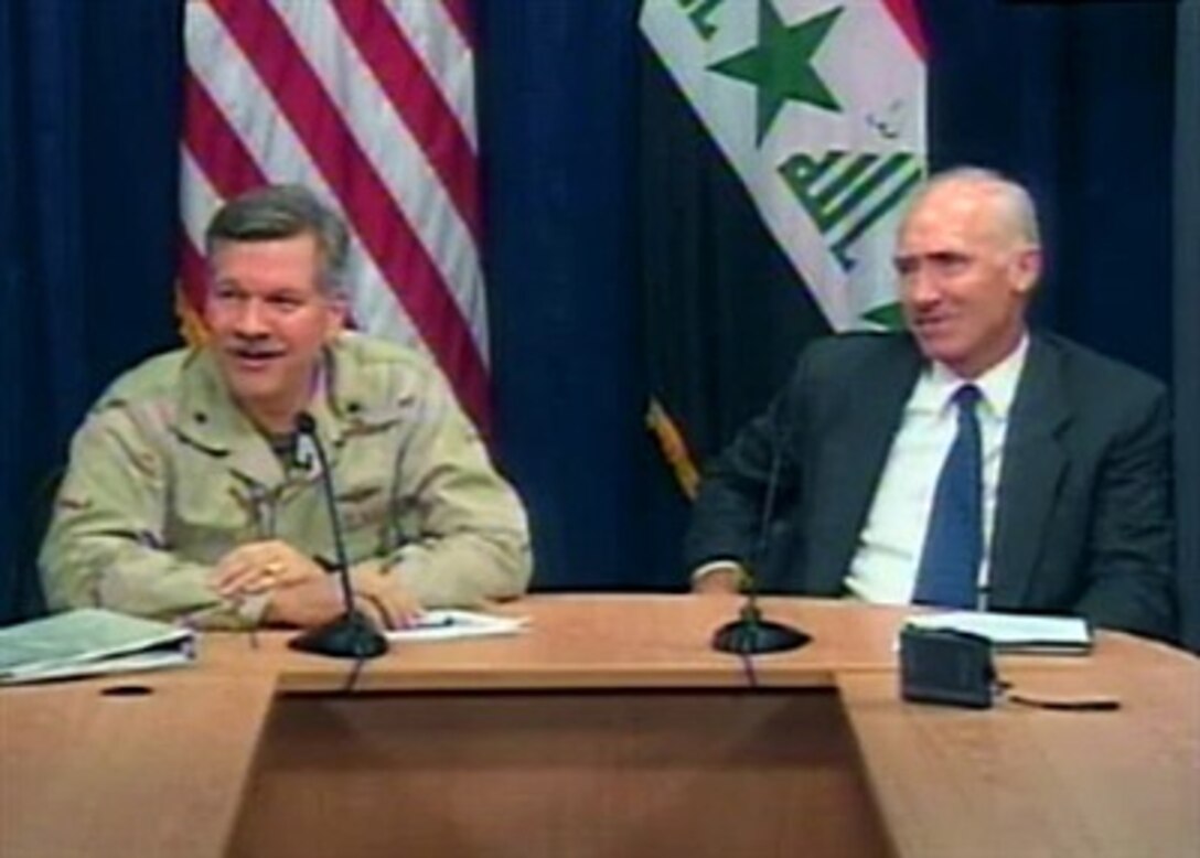 U.S. Navy Rear Adm. Mark Fox, left, chief of Communications Division, Strategic Effects, Multi-National Force-Iraq, and Rick Olson, chief of the Provincial Reconstruction Team, speak with reporters in Iraq, April 9, 2007.