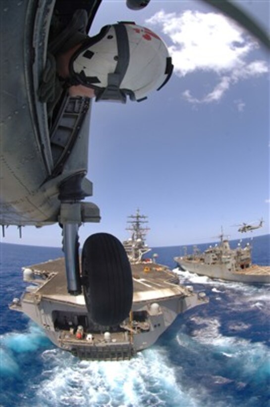 U.S. Navy Petty Officer 2nd Class David Rankin leans out the door of an SH-60 Sea Hawk as the helicopter approaches the flight deck of the aircraft carrier USS Ronald Reagan (CVN 76) during operations in the South China Sea on April 6, 2007.  The Ronald Reagan Carrier Strike Group is under way in the Pacific Ocean on a surge deployment in support of U.S. military operations in the Western Pacific.  Rankin is attached to Helicopter Antisubmarine Squadron 4.  