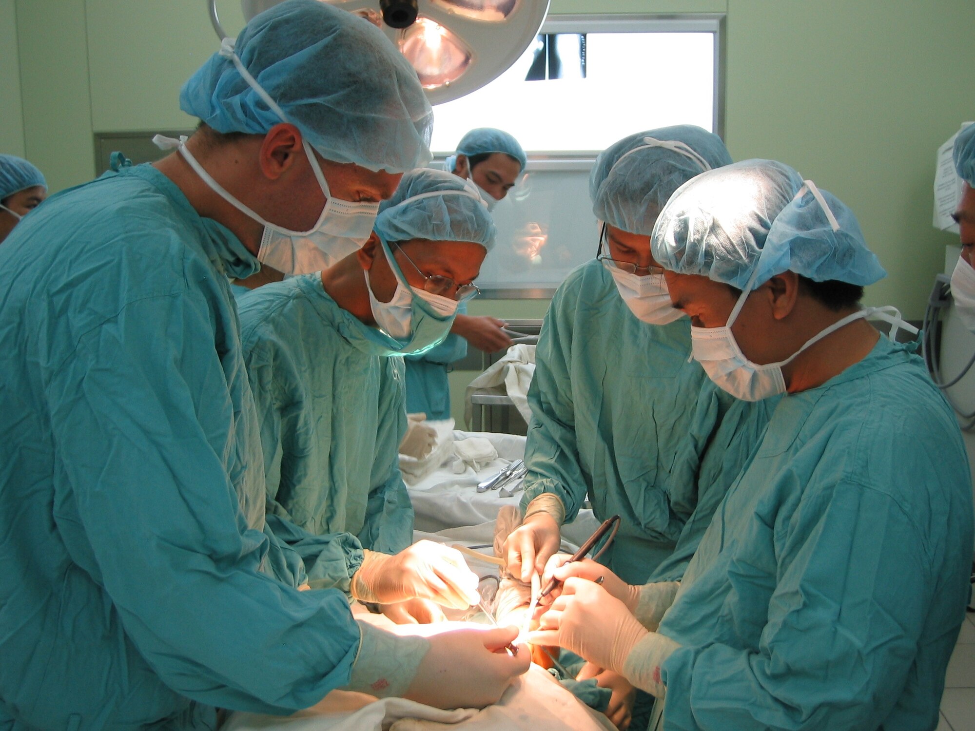 VIETNAM -- Dr. Joe Orchowski, Orthopedics surgeon at Tripler Army Medical Center, (far left)  performing knee replacement surgery with Hue Central Hospital medical staff. This humanitarian assistance effort was funded by US Pacific Command as a high priority Asia-Pacific Regional Initiative. It was planned and executed as a first-ever joint venture by US Army Pacific (USARPAC), Pacific Air Forces, 624 Regional Support Group, and two Non-Governmental Agencies: The East Meets West Foundation (EMWF) based in Vietnam and the AMM based in Hawaii.  (photo by Capt Fritz Craft)