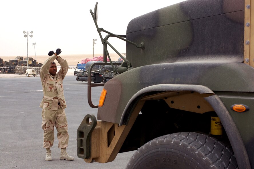 Tech. Sgt. Garth Chablal guides one of 32 M916 trucks onto scales for weighing in preparation for shipment on C-17 Globemaster IIIs. Squadrons across the 379th Air Expeditionary Wing have picked up operations along with surge operations in Iraq and Afghanistan. Sergeant Chabal is the air freight supervisor of the 8th Expeditionary Air Mobility Squadron. (U.S. Air Force photo/Senior Airman Erik Hofmeyer)
