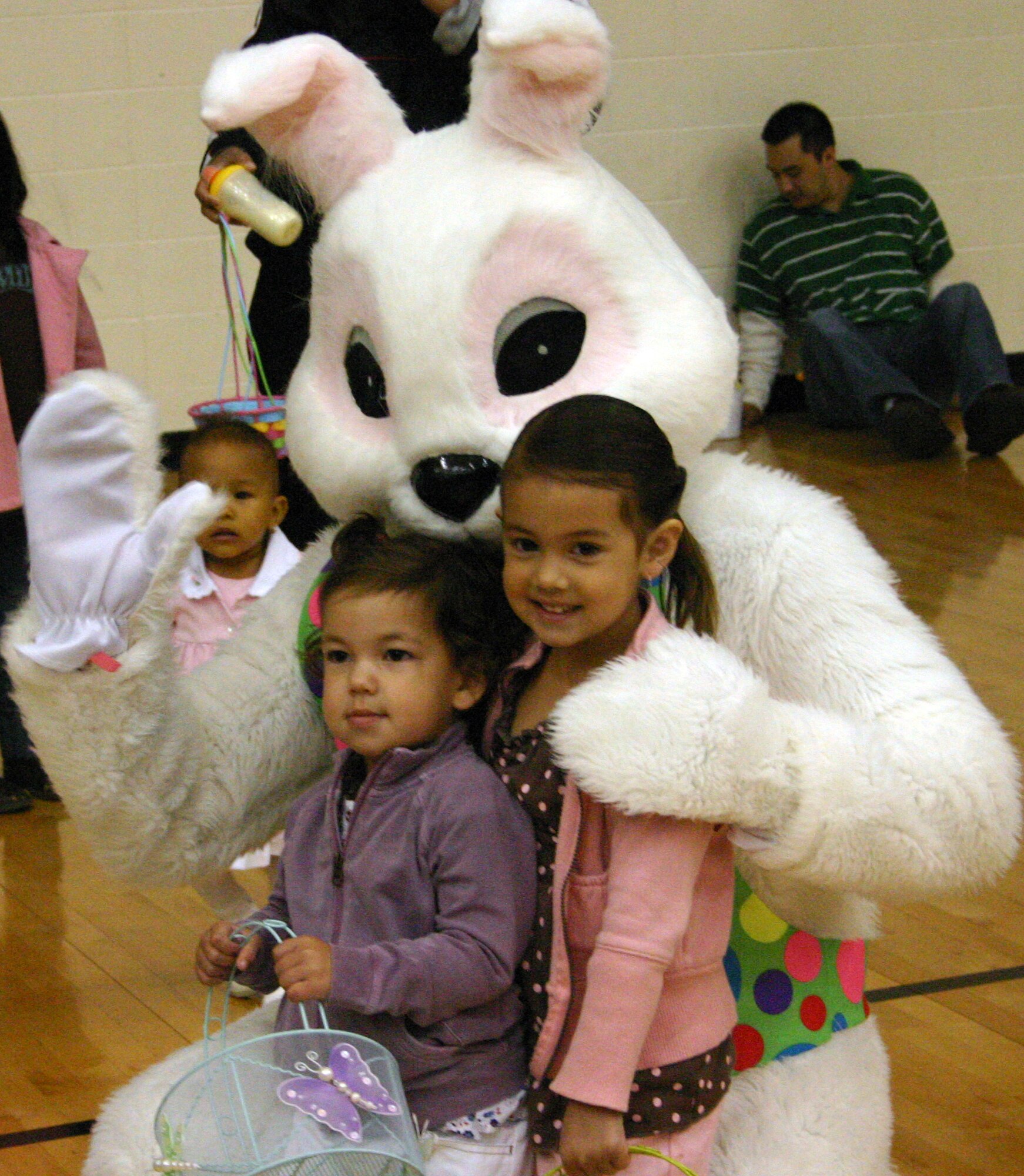 LAUGHLIN AIR FORCE BASE, Texas -- Maya and Layla Smith, daughters of Capt. Lance and Jessie Smith, 47th Flying Training Wing legal office, take pictures with the Easter bunny after collecting Easter eggs in the Losano Fitness Center's gym Saturday morning, after rain caused the other activities that were scheduled for the day to be cancelled.(U.S. Air Force photo by Airman Sara Csurilla)