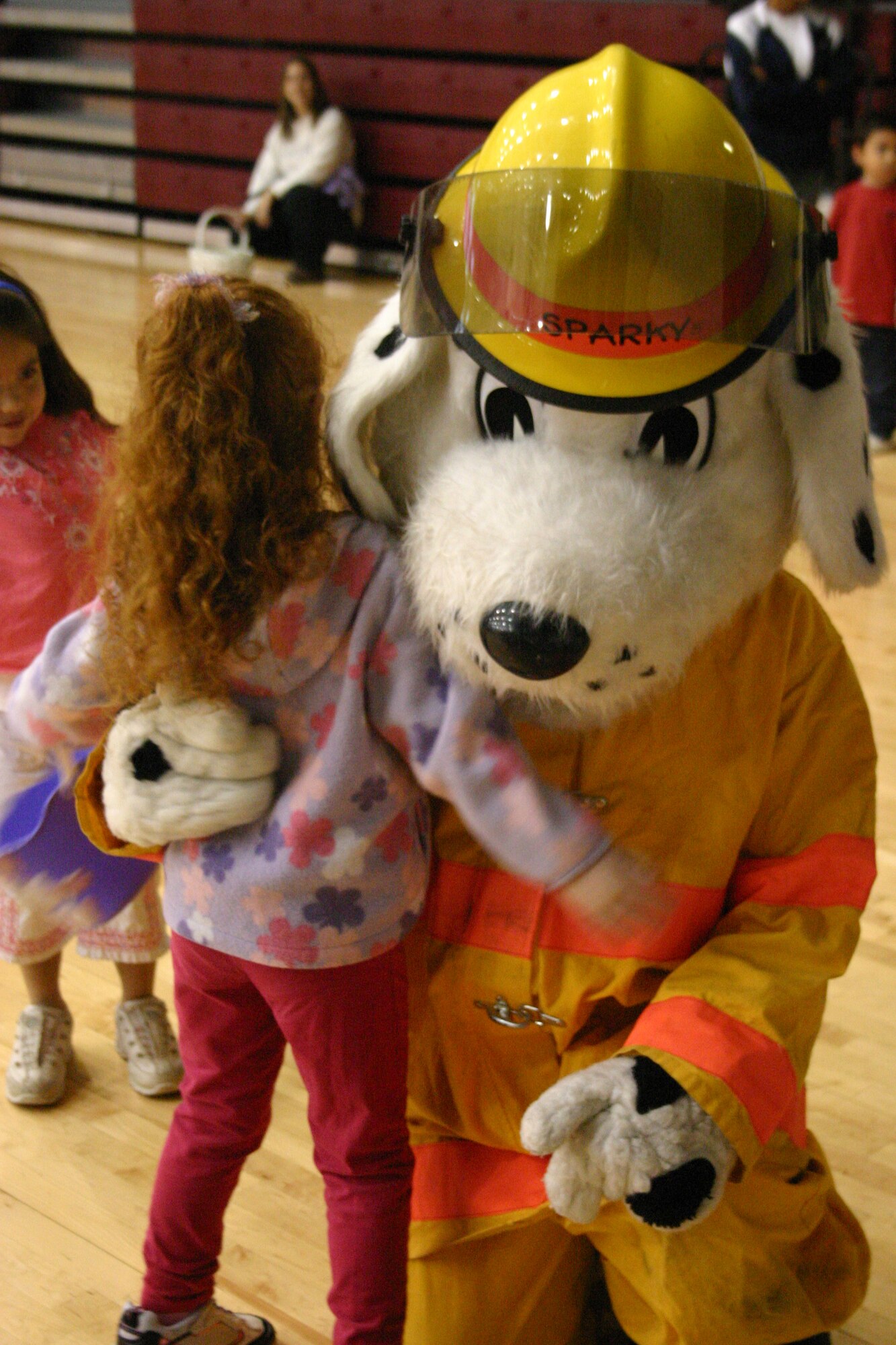 LAUGHLIN AIR FORCE BASE, Texas -- Danielle Hower, daughter of Tech. Sgt. Joel and Laura Langton, 47th Flying Training Wing, gives ?Sparky the Fire Dog? a hug before she starts to hunt for Easter eggs in the Losano Fitness Center?s gym Saturday morning.(U.S. Air Force photo by Airman Sara Csurilla)