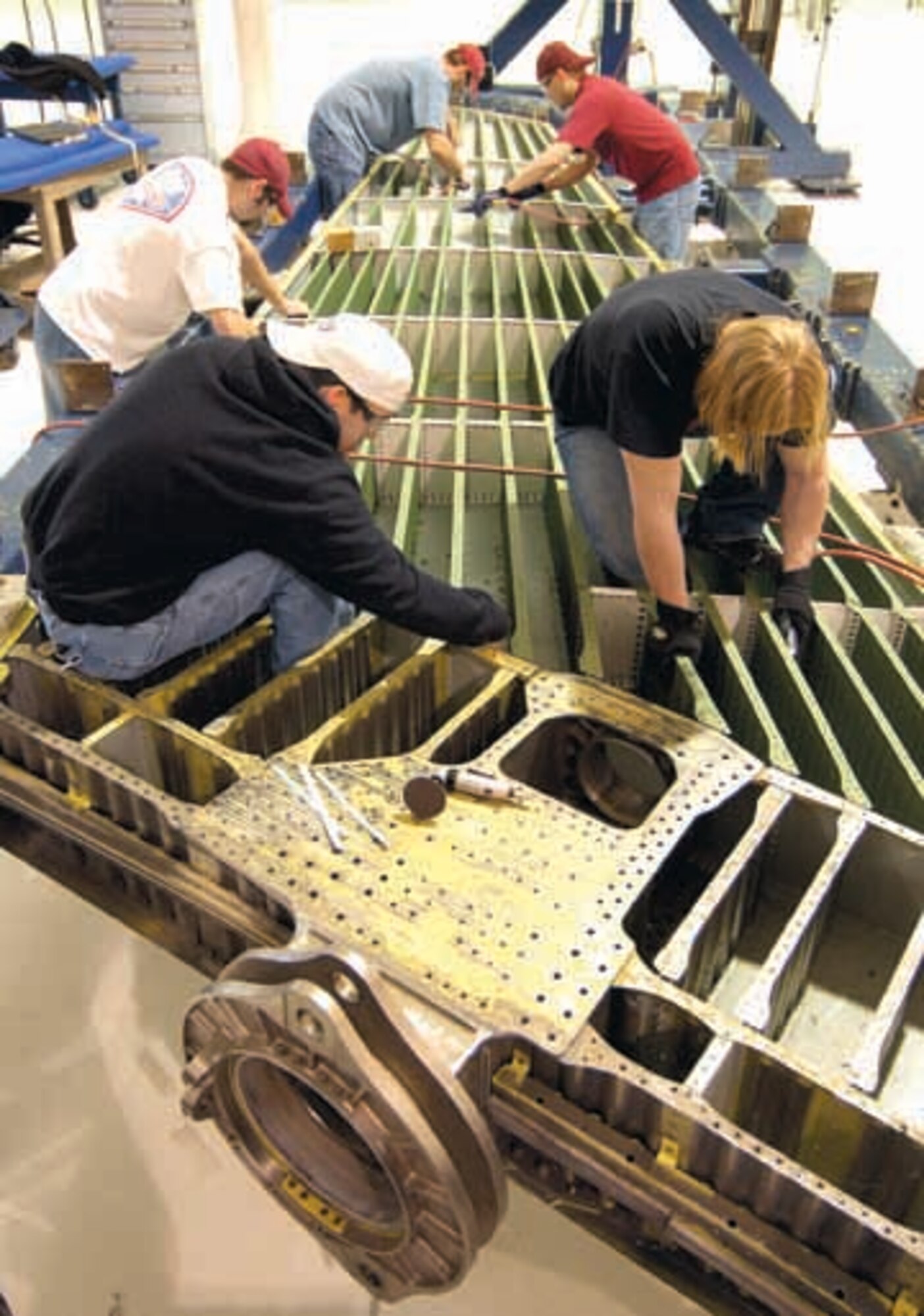 B-1 Horizontal Stabilizer Shop personnel replace aluminum spars with titanium on one of the last two stabilizers modified for the 77-bomber inventory.  Part of the team completing the eight-year workload at Tinker are; clockwise from left; Chris Johnson, Donny Ticer, Brenton Bryant, John Griffin and Charles Guthrie.  (Air Force photo by Margo Wright)


