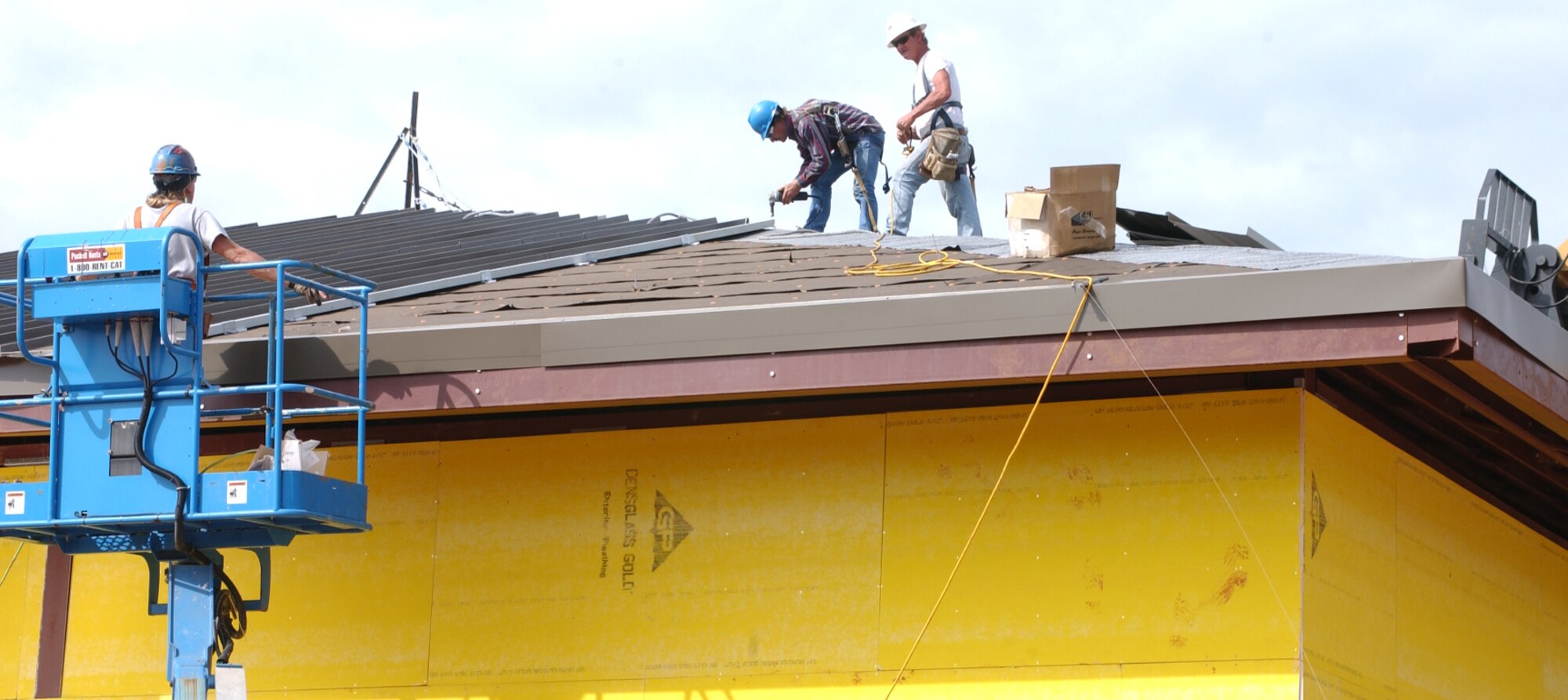 From left, Randall Beard, Ralph Gimelot and Billy McGurk of Scott Co., Lucedale, Miss., work on the roof of the Army and Air Force Exchange Service service station complex under construction at the corner of Larcher Boulevard and Meadows Drive.  (U.S. Air Force Photo by Kemberly Groue)