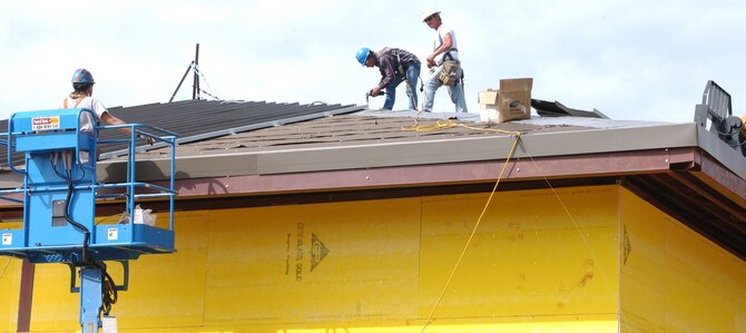 From left, Randall Beard, Ralph Gimelot and Billy McGurk of Scott Co., Lucedale, Miss., work on the roof of the Army and Air Force Exchange Service service station complex under construction at the corner of Larcher Boulevard and Meadows Drive.  (U.S. Air Force Photo by Kemberly Groue)