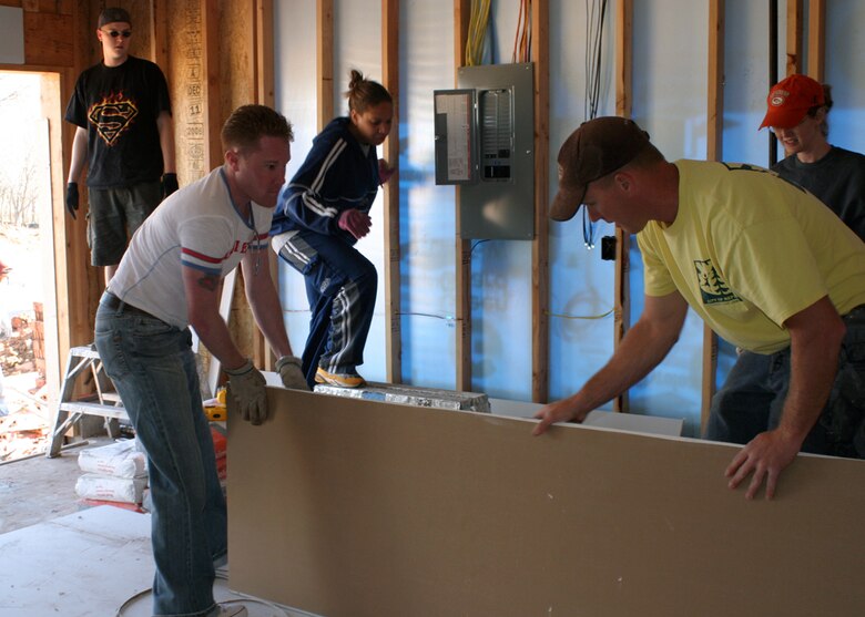 (TINKER AIR FORCE BASE, Okla.) Airmen from the 552nd Air Control Wing prepare drywall for the roof of a new garage for a family in need in Oklahoma City. Airmen in the 552nd participate in the Habitat for Humanity program at least twice a year as way to give back to the communities that surround Tinker. (Air Force photo by Senior Airman Lorraine Amaro)