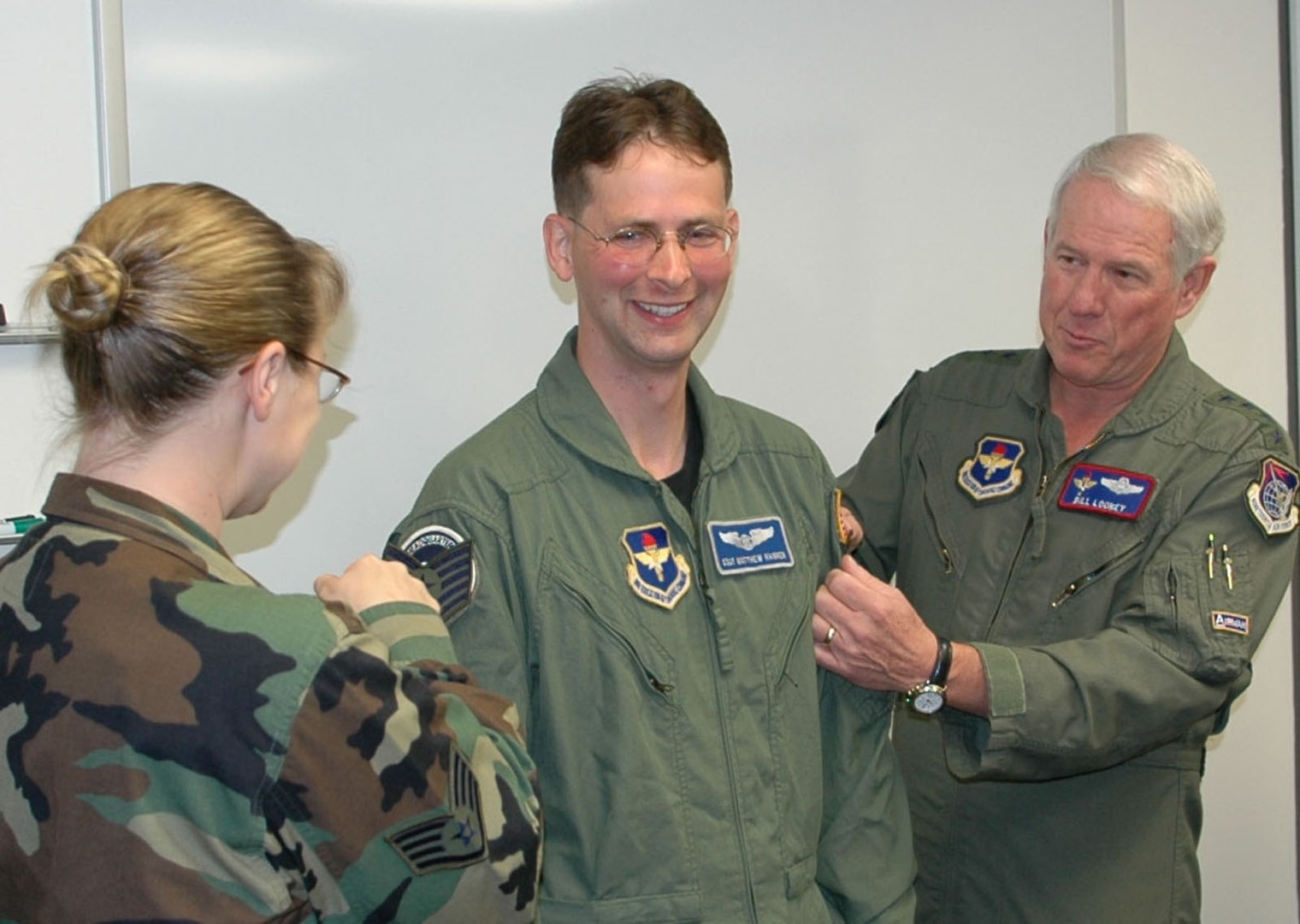 Gen. William R. Looney III, Air Education and Training Command commander, and Staff Sgt. Marisa Hannen "tack" technical sergeant stripes onto newly-promoted Tech. Sgt. Matthew Hannen Friday at the AETC Safety Directorate.  General Looney surprised Sergeant Hannen, photographer for Torch Magazine, with a promotion under the Stripes For Exceptional Performers program.  (U.S. Air Force photo by Master Sgt. Randall Soli)