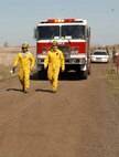 FAIRCHILD AIR FORCE BASE, Wash. – Airman 1st Class Jose Flores and Abraham Nisbet, 92nd Civil Engineer Squadron firefighters, guide a fire engine down a dirt road leading to a brush fire on the explosive ordinance disposal range here April 6. The Fairchild Fire Department responded to and contained the brush fire that consumed around 15 acres. (U.S. Air Force photo/Airman 1st Class Joshua Chapman)