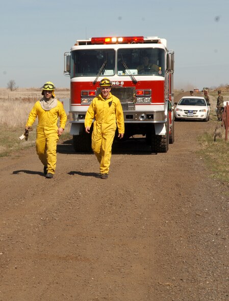 FAIRCHILD AIR FORCE BASE, Wash. – Airman 1st Class Jose Flores and Abraham Nisbet, 92nd Civil Engineer Squadron firefighters, guide a fire engine down a dirt road leading to a brush fire on the explosive ordinance disposal range here April 6. The Fairchild Fire Department responded to and contained the brush fire that consumed around 15 acres. (U.S. Air Force photo/Airman 1st Class Joshua Chapman)
